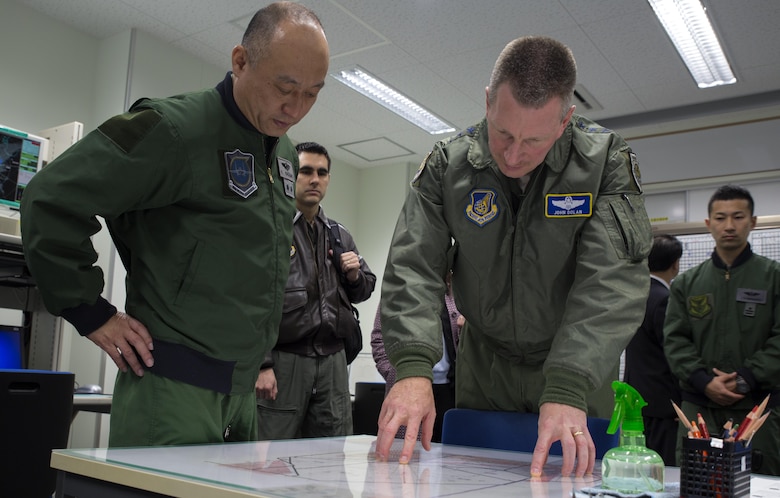 Maj. Gen. Kenichiro Nagumo, 6th Air Wing commanding general, and Lt. Gen. John L. Dolan, commander of U.S. Forces Japan and 5th Air Force, study a flight diagram during a visit to Komatsu Air Base, Japan, March 9, 2016. Dolan visited Komatsu Air Base for the first time to observe the Komatsu Aviation Training Relocation exercise between Marine Fighter Attack Squadron (VMFA) 314 and Japanese Air Self-Defense Force. The ATR program has three main goals;  to increase operational readiness, improve interoperability, and reduce local noise impacts. (U.S. Marine Corps photo by Cpl. Nicole Zurbrugg/Released)