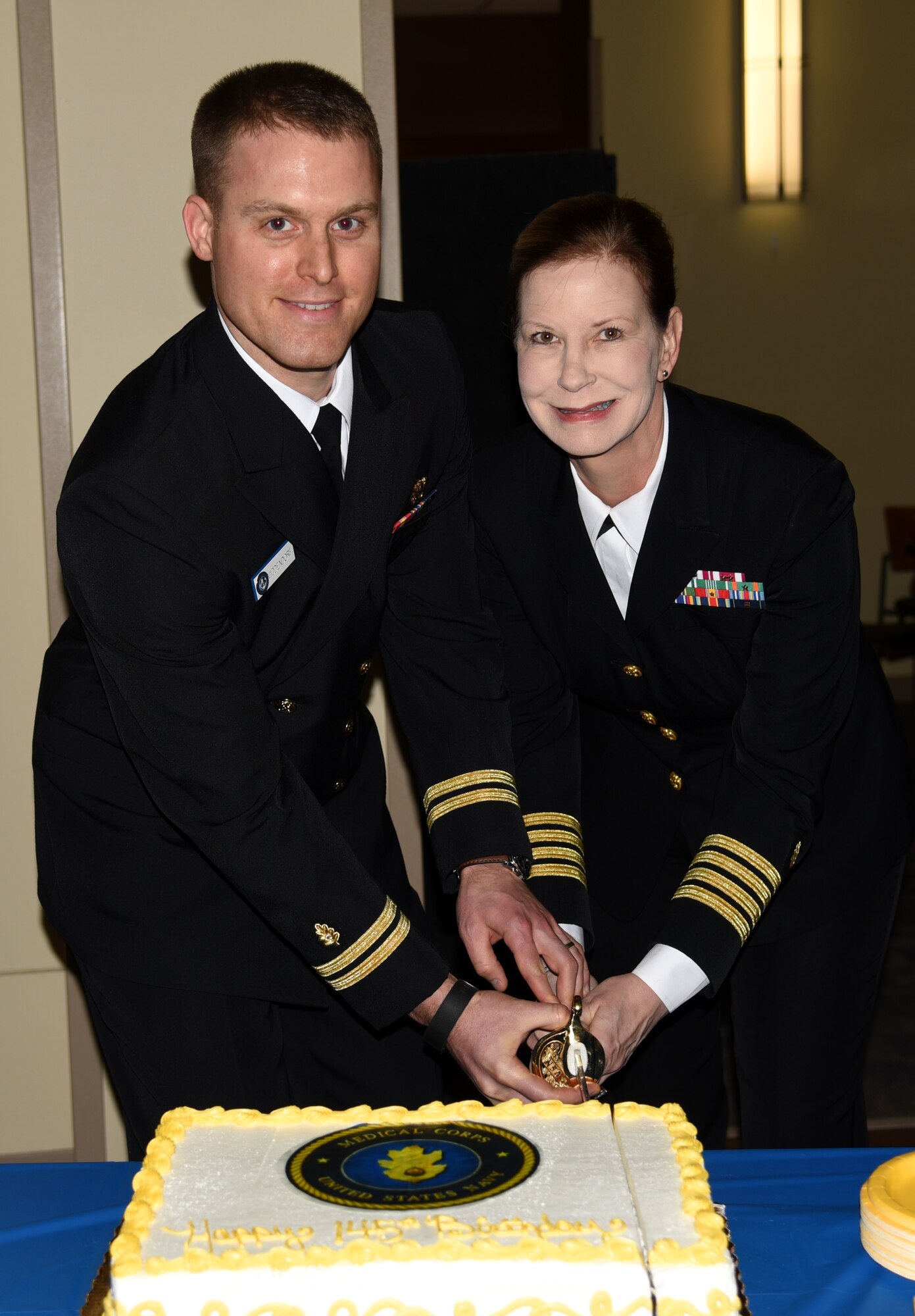 Lt. Matthew Middendorf, a physician at Naval Health Clinic Charleston, and Capt. Rosemary Malone, a psychiatrist and NHCC executive officer, cut the cake during NHCC's celebration of the Navy Medical Corps' 145th birthday March 4, 2016 at NHCC, Joint Base Charleston - Weapons Station. The Navy Medical Corps was founded on March 3, 1871 and consists of physicians in a variety of specialties. (U.S. Navy photo/ Kris Patterson)
