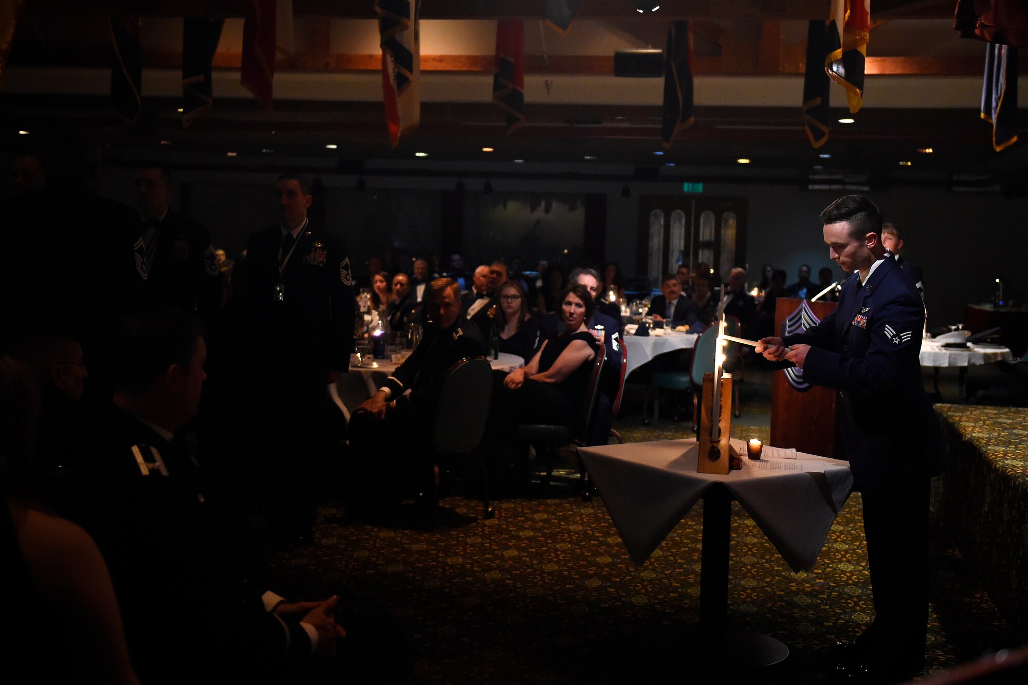Senior Airman Josh Beeler, 8th Airlift Squadron loadmaster, lights a candle during the chief master sergeant induction ceremony March 4, 2016, at Joint Base Lewis-McChord, Wash. During the ceremony a candle is lit for each rank of the enlisted structure an Airmen wears on their way to the rank of chief master sgt. (U.S. Air Force photo/Tech. Sgt. Tim Chacon)  