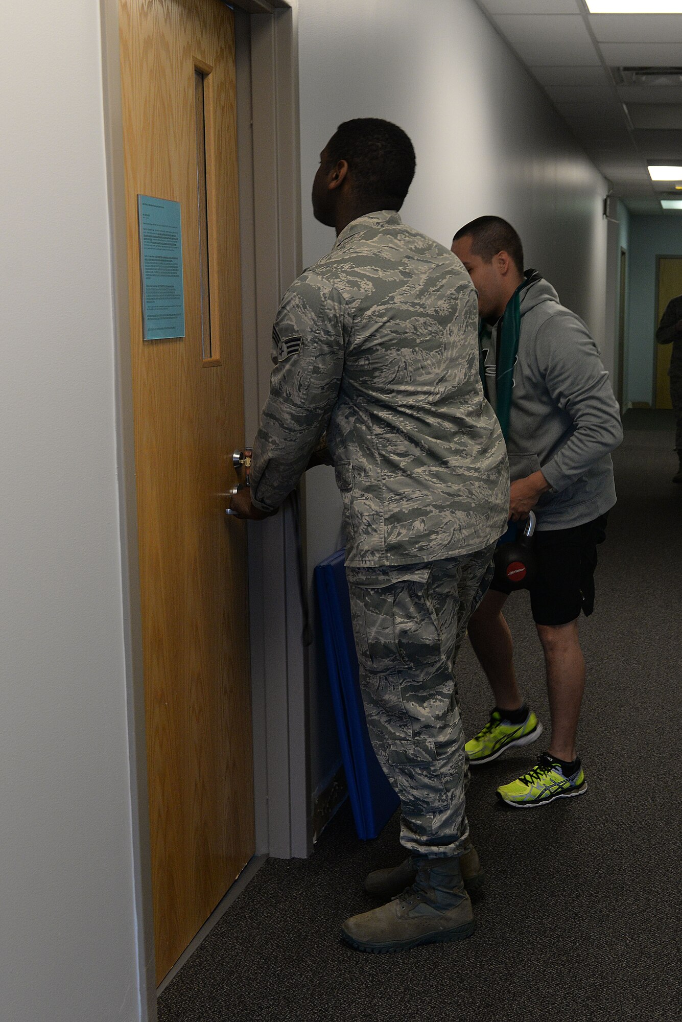 Senior Airman Elijah Sherman, an Airman assigned to the 5th Force Support Squadron, unlocks an individual workout room for a patron of McAdoo Fitness Center at Minot Air Force Base, N.D., March 9, 2016. Individual workout rooms, which have workout-DVD capabilities, are ideal for patrons who prefer privacy. (U.S. Air Force photo/Airman 1st Class Jessica Weissman)