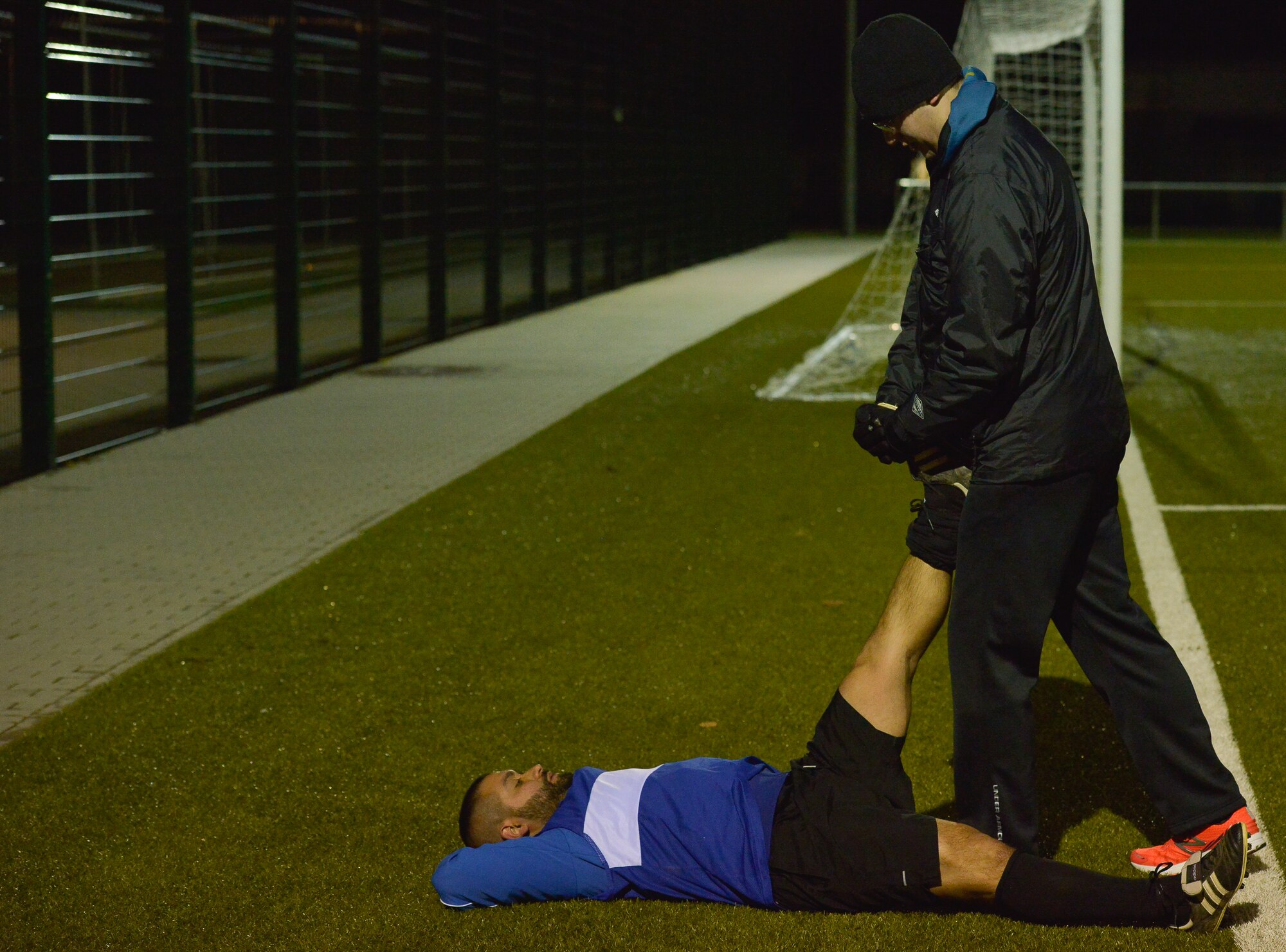 First Lt. Sean Miller, 7th Weather Squadron chief of education and training, helps one of his players stretch during practice Mar. 3, 2016, at U.S. Army Garrison Wiesbaden, Germany. Miller is the coach of a local soccer team in Wiesbaden, and was recently appointed as the Air Force soccer team assistant coach. (U.S. Air Force photo/Airman 1st Class Lane T. Plummer)