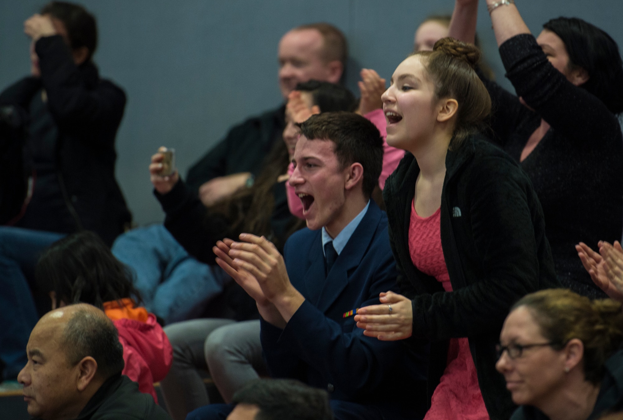 Spectators cheer as awards are presented during the annual Department of Defense Education Activity Europe drill team championship held on Vogelweh, Germany, March 5, 2016. Approximately 100 cadets from 11 junior ROTC from across Europe gathered at Kaiserslautern High School to compete in the annual event. (U.S. Air Force photo Senior Airman Jonathan Stefanko)