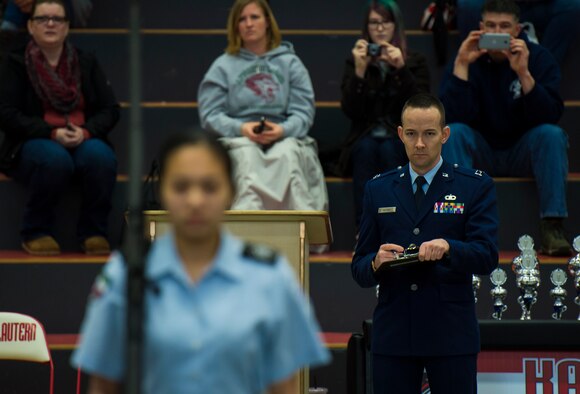 Capt. Brandon Alford, 7th Weather Squadron chief of contingency plans and programs, judges a junior ROTC drill performance during the annual Department of Defense Education Activity Europe drill team championship held on Vogelweh, Germany, March 5, 2016. Approximately 100 Air Force and Navy junior ROTC teams from across Europe gathered at Kaiserslautern High School to compete in the annual event. (U.S. Air Force photo Senior Airman Jonathan Stefanko)
