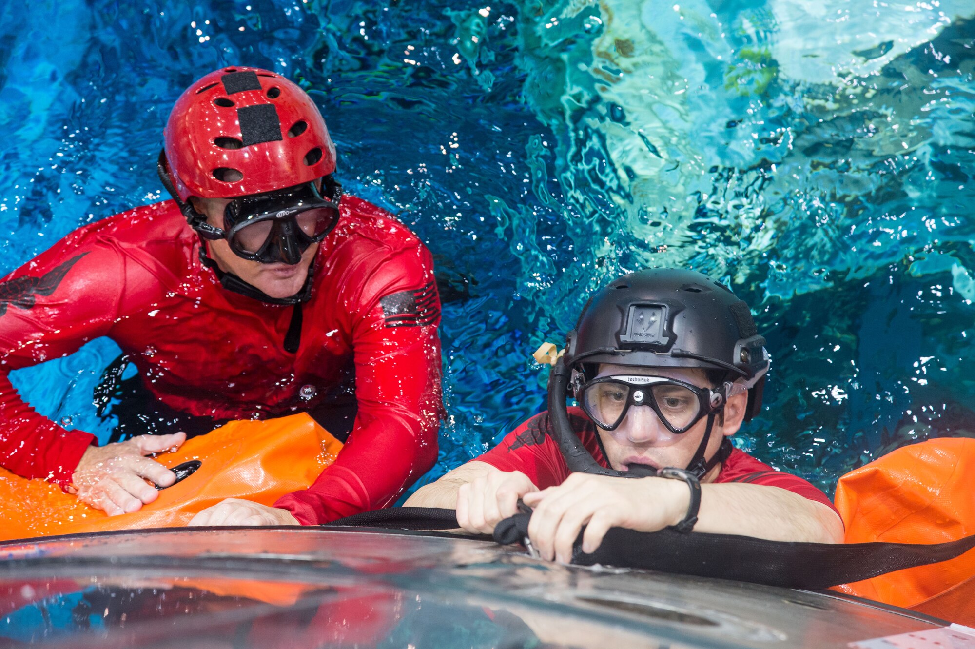 Master Sgt. Chris Seinkner, 308th Rescue Squadron, Patrick AFB, Fla., teams up with Staff Sgt. Eli Reynolds, of the 88th Test and Evaluation Squadron, Nellis AFB, Nev., to install the stabilization collar on the Orion Capsule during a recent exercise at NASA’s Neutral Buoyancy Lab in Houston, Texas. The Air Force and NASA work together to prepare for contingency landing site support, payload security, medical support, coordination of airlift/sealift for contingency operations, as well as other support services required in the event of a spacecraft emergency. The 45th Operations Group’s Detachment 3, located at Patrick AFB, was chartered in 1959 by the Secretary of Defense as the DoD Mercury Support Office [later renamed DoD Manned Space Flight Support Office (DDMS)], its express purpose is providing DoD support to our nation's human space flight programs, putting people into space and returning them safely to Earth. (Courtesy photo/NASA)
