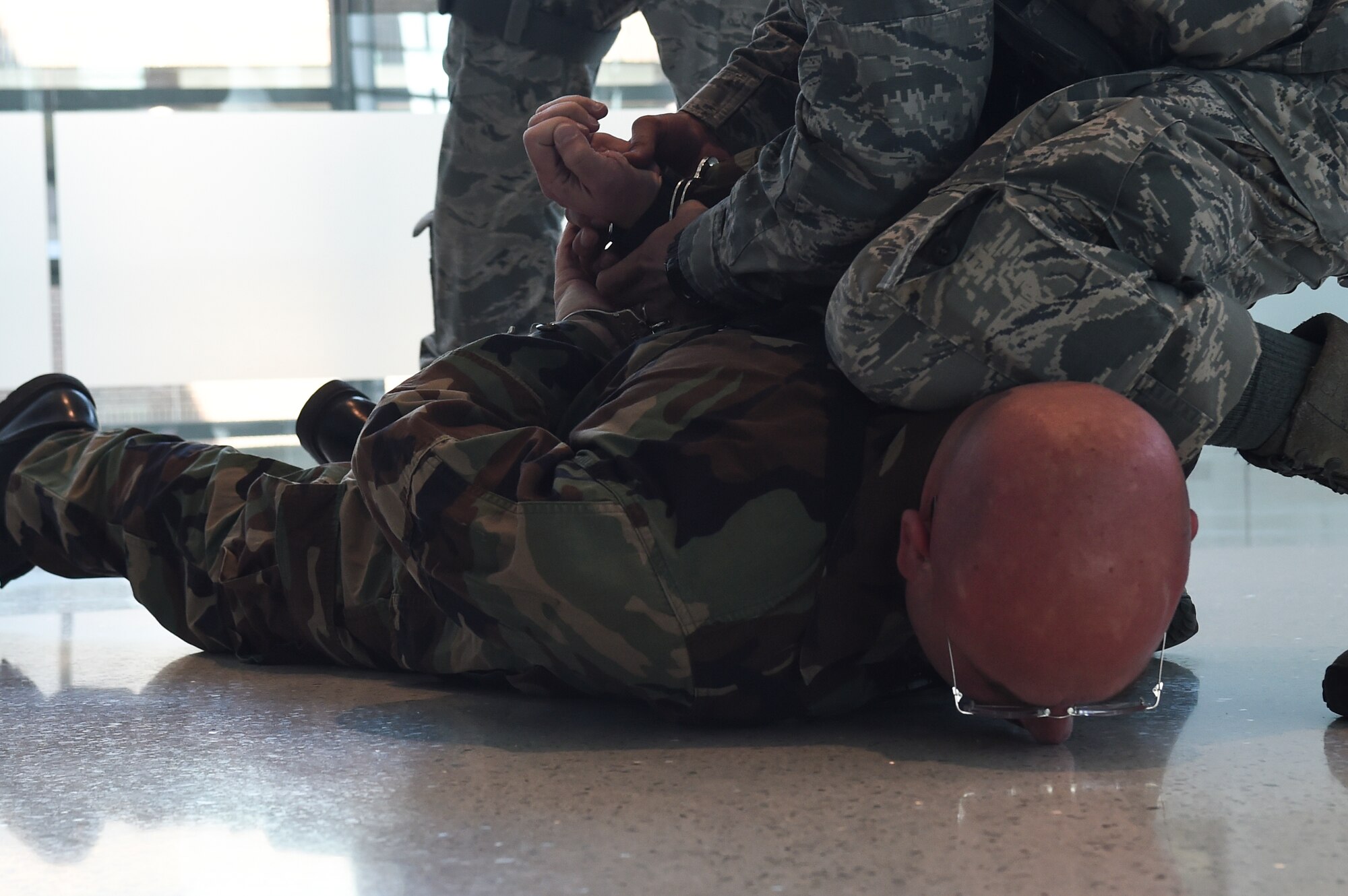 11th Security Forces Squadron Airmen arrest an active shooter during an exercise on Joint Base Andrews, Md., March 9, 2016. Exercise programs utilize dynamic interactive scenarios to evaluate proficiency in individual and team responses.(U.S. Air Force photo by Senior Airman Mariah Haddenham/Released)