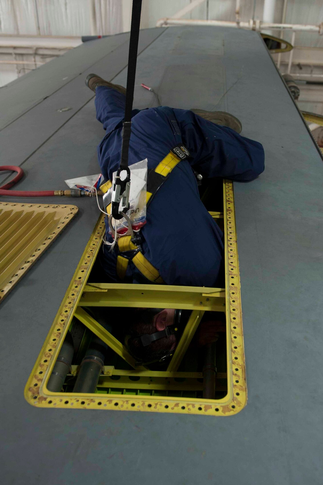 U.S. Air Force Senior Airman 1st Class Dennis Williams, 19th Maintenance Squadron sheet metal journeyman, enters a fuel tank on a C-130 Mar. 4, 2016, at Little Rock Air Force Base, Ark. Airmen are required to wear specially made coveralls and respirators whenever they enter a fuel tank. (U.S. Air Force photo by Airman 1st Class Mercedes Taylor) 