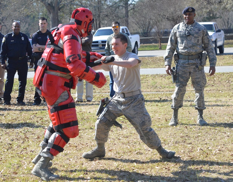 Dressed in a red protective suit, Staff Sgt. Kyle Gruver, 78th SFS training instructor, takes a defensive posture during training with Airman 1st Class John White, while Staff Sgt. Jeremy Jackson, right, monitors. (U.S. Air Force photo by Ray Crayton) 

