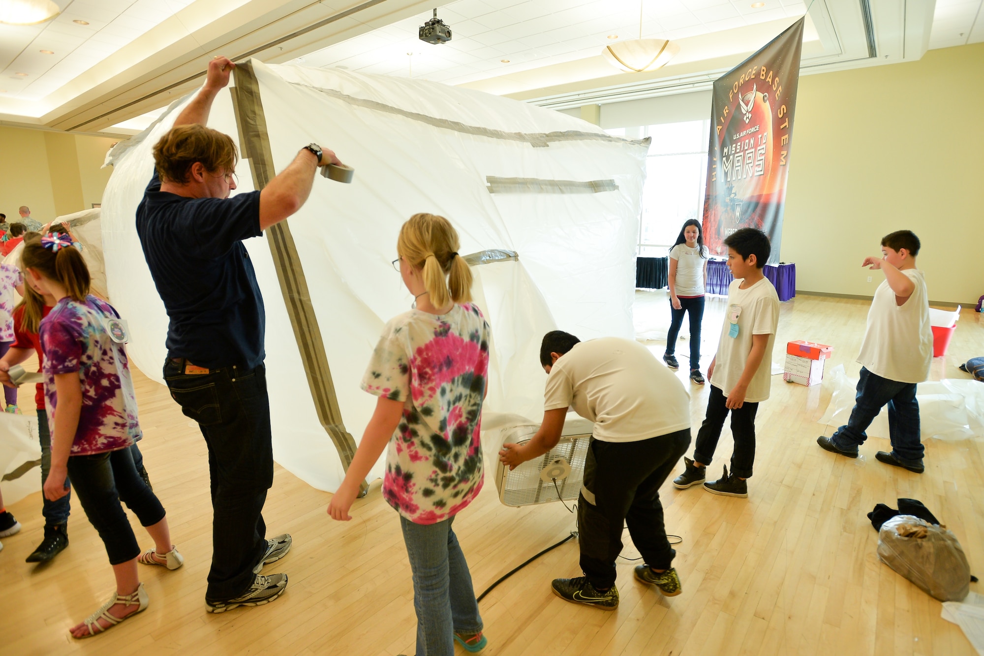 Hill Air Force Base volunteer Corbin Bell assists students in inflating their habitat during a ‘Mission to Mars’ STEM event at Weber State University, Ogden, Utah, March 9, 2016. (U.S. Air Force photo by R. Nial Bradshaw)