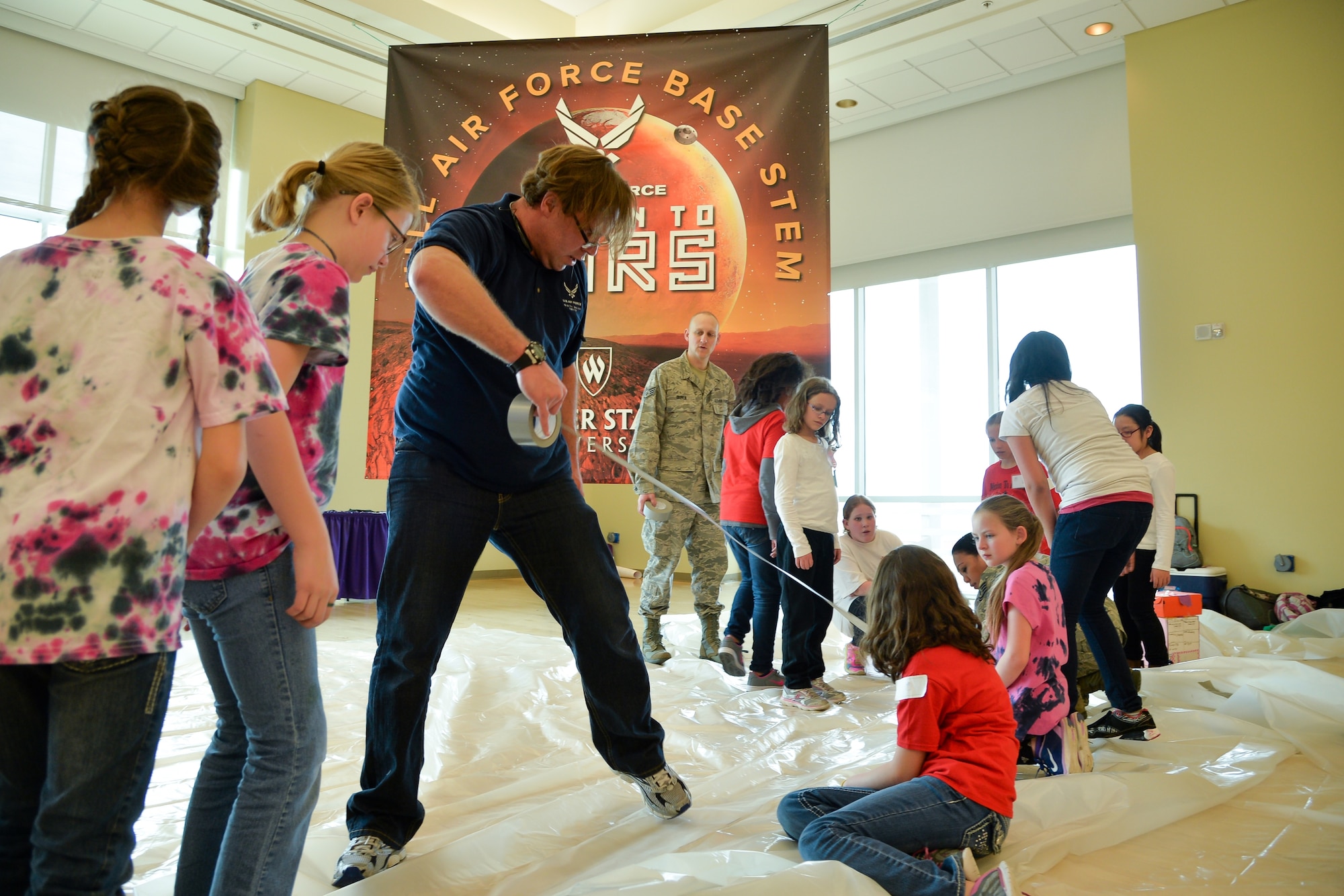 Hill Air Force Base volunteer Corbin Bell assists students in constructing a habitat during the ‘Mission to Mars’ STEM event held at Weber State University, Ogden, Utah, March 9, 2016. (U.S. Air Force photo by R. Nial Bradshaw)
