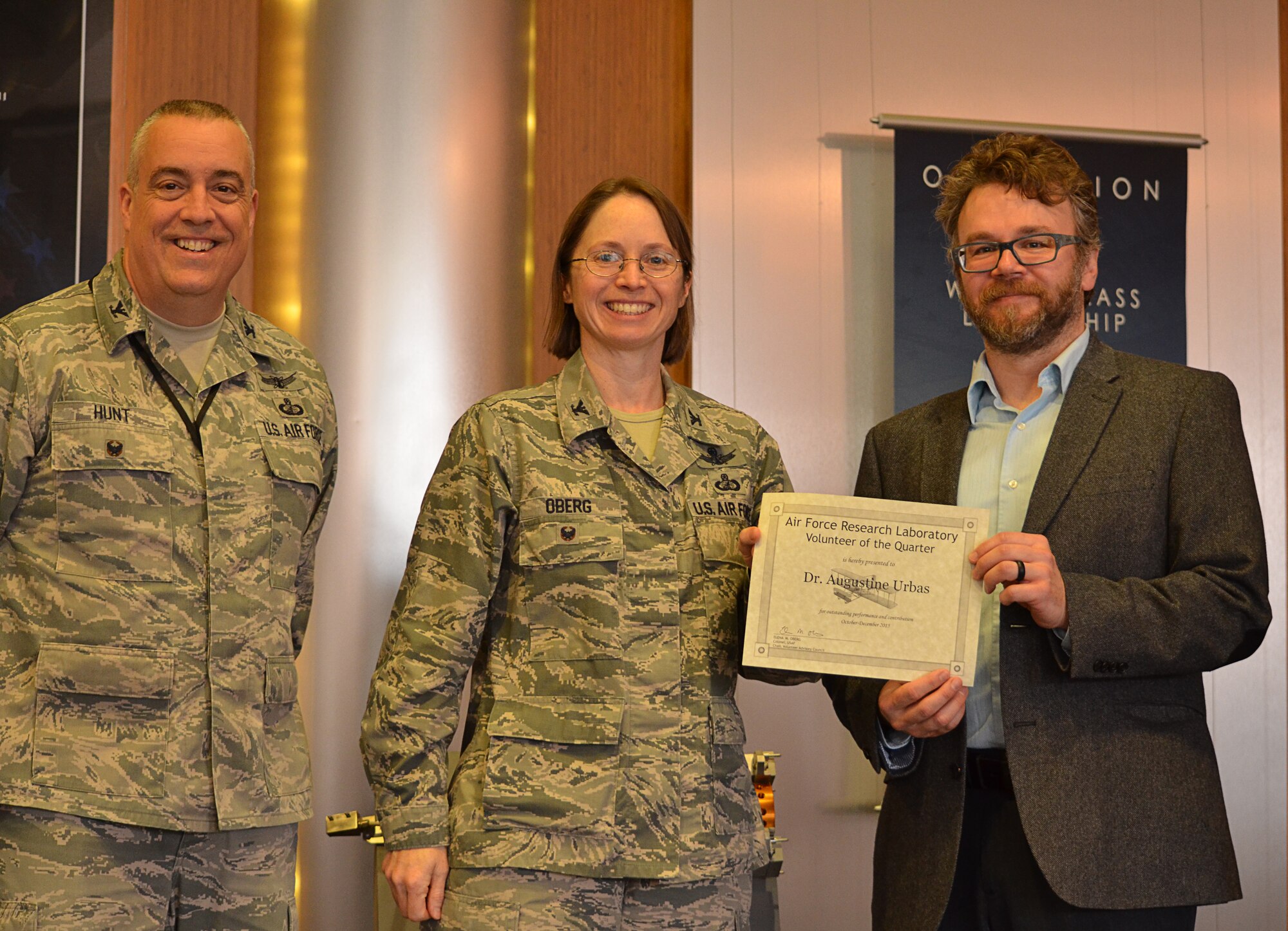 Vice Commander of the 88th Air Base Wing Colonel Elena Oberg, along with Colonel Frederick Hunt, Deputy Director of the AFRL Materials and Manufacturing Directorate, present Dr. Augustine Urbas with the Wright-Patterson Volunteer of the Quarter award at a March 9, 2016, ceremony for his work with Dayton high school students.  (U.S. Air Force photo/Marlana Sanders)