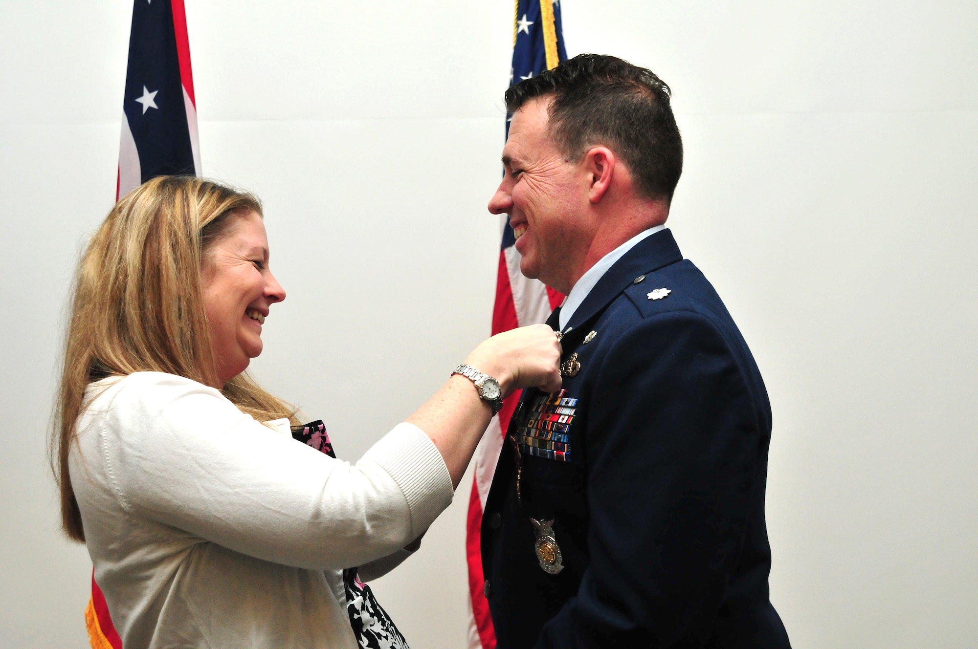 Melanie Craig, the wife of Lt. Col. Matthew Craig, presents her husband with a pin to honor his retirement from the 178th Wing at Springfield Air National Guard Base, Ohio, March 6, 2016. Craig, the 178th Wing Civil Engineering Squadron commander, enlisted in the U.S. Air Force in 1992 and received his commission in 1998. During his time as commander, he worked on several major construction projects to ensure base facilities met the needs of the 178th Wing's mission change. (Ohio Air National Guard photo by Airman 1st Class Rachel Simones)