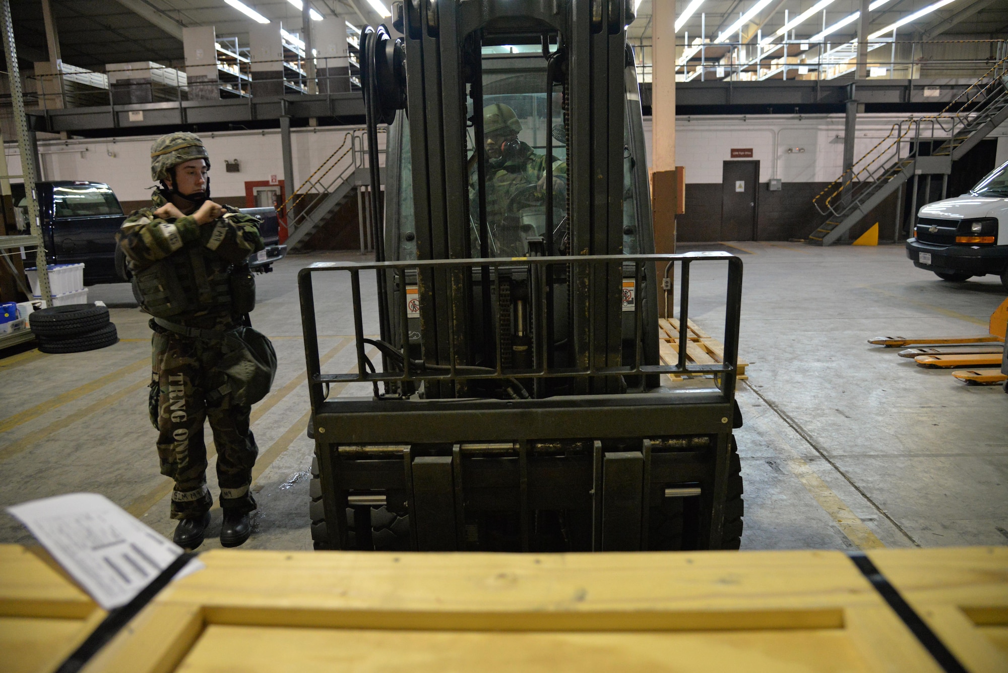 Senior Airman Justin Shepherd-Helm guides Senior Airman Sterling Tutt toward a wooden box to pick it up with a forklift during Exercise Beverly Midnight 16-01 at Osan Air Base, Republic of Korea, March 9, 2016. Shepherd-Helm and Tutt are both 51st Logistics Readiness Squadron documented cargo section vehicle operator dispatchers. The documented cargo section delivers mission essential cargo to units across the base to ensure aircraft and other Air Force assets are ready and available for use. (U.S. Air Force photo by Tech. Sgt. Travis Edwards/Released)