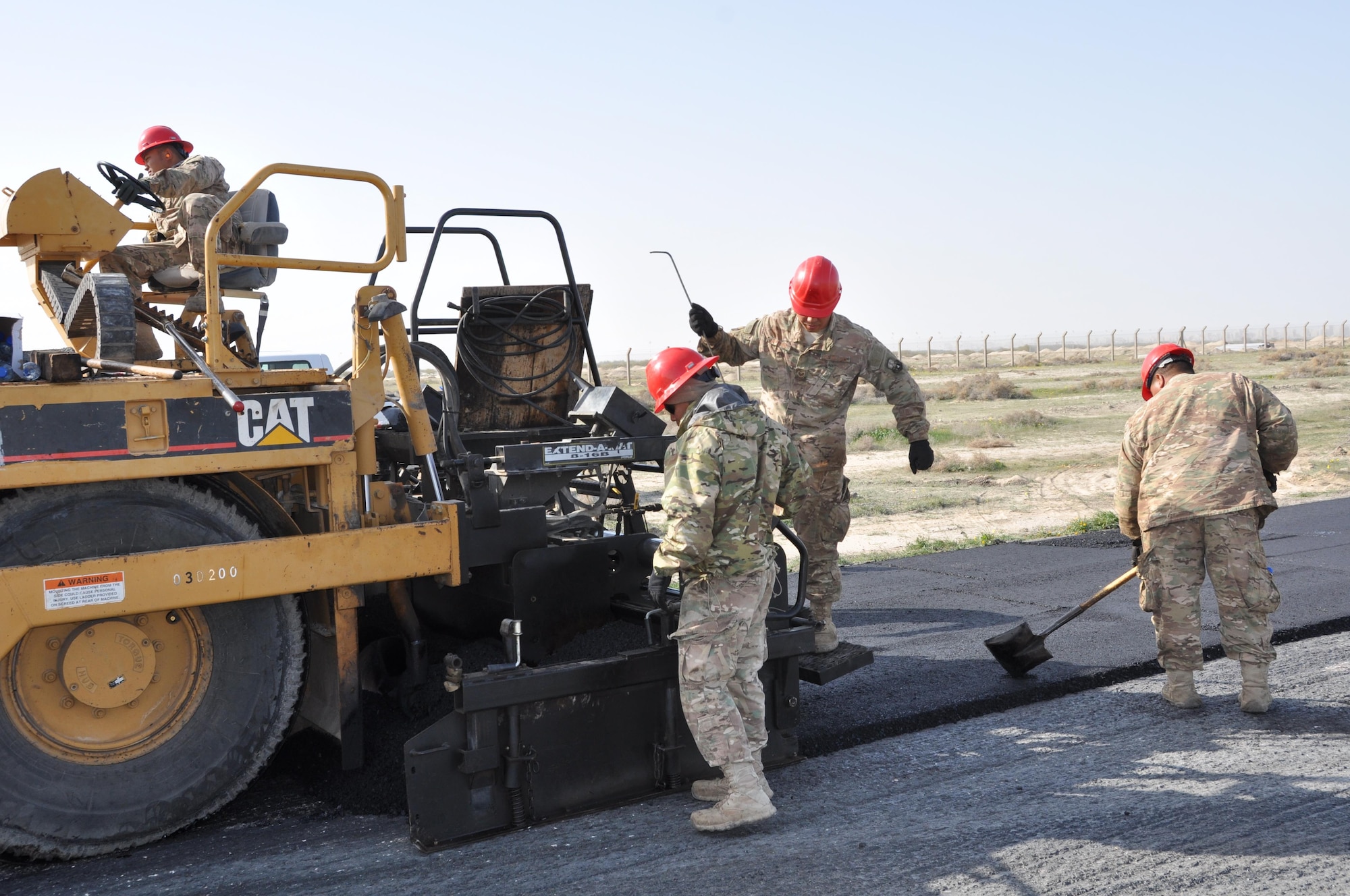 Members of the 557th Expeditionary Civil Engineers Group, Red Horse, construct a 2 mile long access road at an undisclosed location in Southwest Asia, January 20, 2016.  Red Horse personnel working this paving project are deployed from the 254th in Guam, Montana’s 219th, and the 210th out of New Mexico.  (U.S. Air Force photo by Master Sgt. Kevin Nichols)
