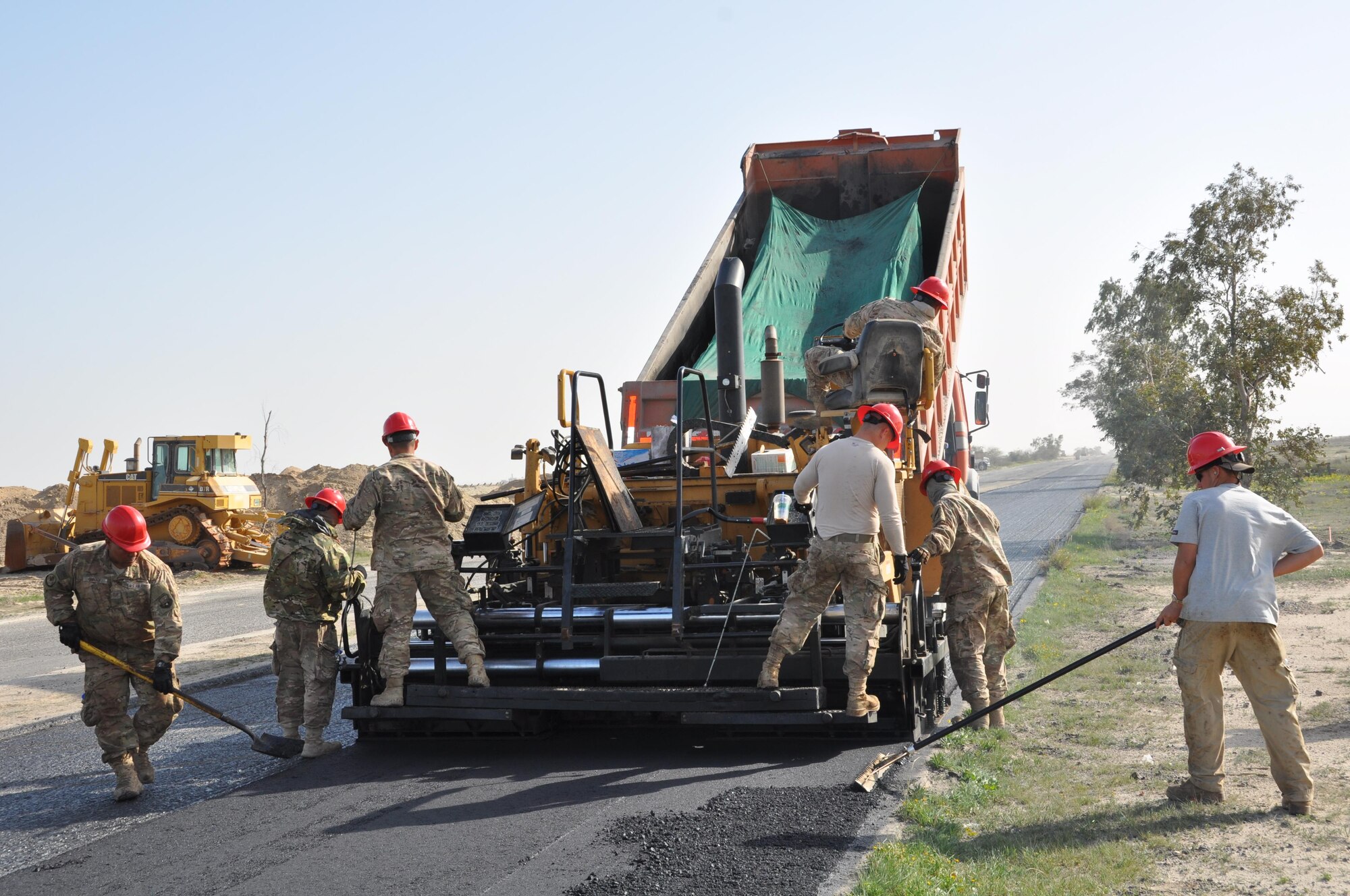 Members of the 557th Expeditionary Civil Engineers Group, Red Horse, construct a 2 mile long access road at an undisclosed location in Southwest Asia, January 20, 2016.  Red Horse personnel working this paving project are deployed from the 254th in Guam, Montana’s 219th, and the 210th out of New Mexico.  (U.S. Air Force photo by Master Sgt. Kevin Nichols)