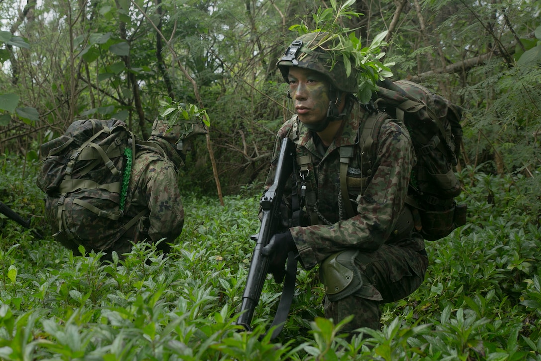 Members of the Japan Ground Self-Defense Force act as security for the main group securing an outpost during a raid mission at Kin Blue, Okinawa Japan, Mar. 11. The intent of the mission was to stop a mock smuggling organization. The JGSDF members incorporated a variety of techniques they observed from 3rd Reconnaissance Battalion, 3rd Marine Division, III Marine Expeditionary Force. The techniques include scout swimming, nautical navigation, beach securing, and reconnaissance. The members are with the 43rd Infantry Regiment.