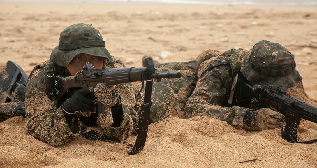 Members of the Japan Ground Self-Defense Force secure a beach during a raid mission at Kin Blue, Okinawa Japan, Mar. 11. The intent of the mission was to stop a mock smuggling organization. The JGSDF members incorporated a variety of techniques they observed from 3rd Reconnaissance Battalion, 3rd Marine Division, III Marine Expeditionary Force. The techniques include scout swimming, nautical navigation, beach securing, and reconnaissance. The members are with the 43rd Infantry Regiment.