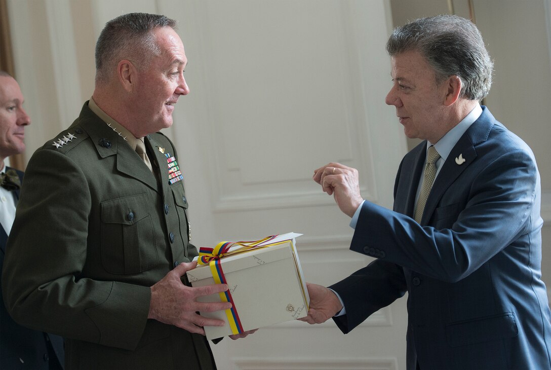 Marine Corps Gen. Joseph F. Dunford Jr., chairman of the Joint Chiefs of Staff, receives a gift from Colombian President Juan Manuel Santos during a meeting in the Palacio de Narino in Bogota, Colombia, March 10, 2016. DoD photo by Navy Petty Officer 2nd Class Dominique A. Pineiro
