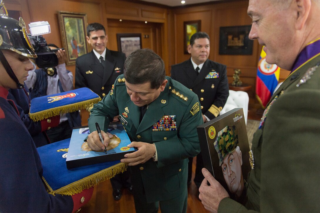 Gen. Juan Pablo Rodriguez, commander of Colombia's armed forces, signs a drawing of the spouse of U.S. Marine Corps Gen. Joseph F. Dunford Jr., chairman of the Joint Chiefs of Staff, right, in Bogota, Colombia, March 10, 2016. DoD photo by Navy Petty Officer 2nd Class Dominique A. Pineiro