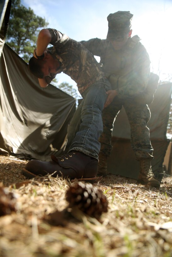 Cpl. Alex Valdez, an electro-optical ordnance repairman and the Evacuation Control Center holding noncommissioned officer in charge, searches a detainee during the battalion’s certification exercise, at Marine Corps Auxiliary Landing Field Bogue, N.C., March 10, 2016. The battalion is slated to deploy on Special Purpose Marine Air-Ground Task Force-Crisis Response-Africa later this year. (U.S. Marine Corps photo by Cpl. Joey Mendez)