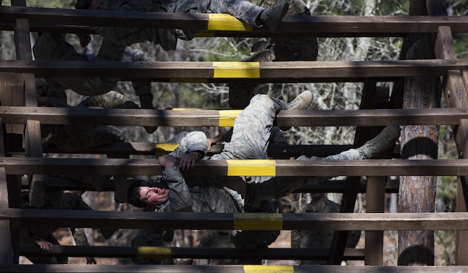 Combat camera Airmen and Soldiers weave through an obstacle on the confidence course during exercise Scorpion Lens March 6, 2016, at Fort Jackson, S.C. The purpose of the training is to provide refresher training to combat camera personnel of all ranks and skill levels in basic tactics, techniques, and procedures inherent to combat camera mission tasking. (U.S. Air Force photo/Staff Sgt. Perry Aston)