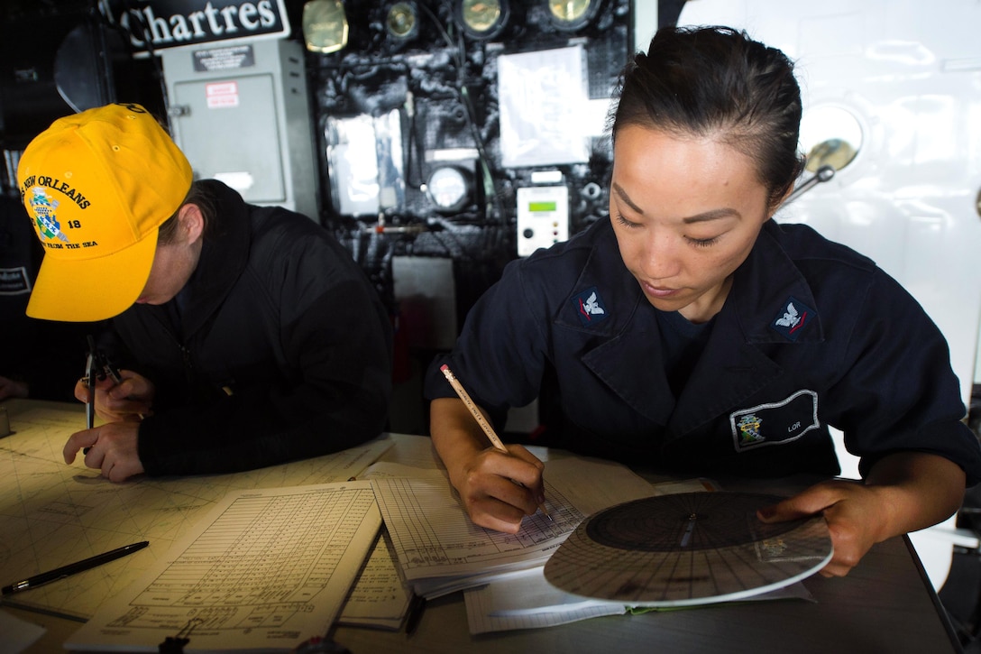Navy Petty Officer 3rd Class Christina Lor, right, and Navy Ensign Kristin Rovito chart course, speed, and winds on the bridge of the amphibious transport dock ship USS New Orleans in the Pacific Ocean, March 2, 2016. Lor is a quartermaster. Navy photo by Petty Officer 3rd Class Chelsea D. Daily