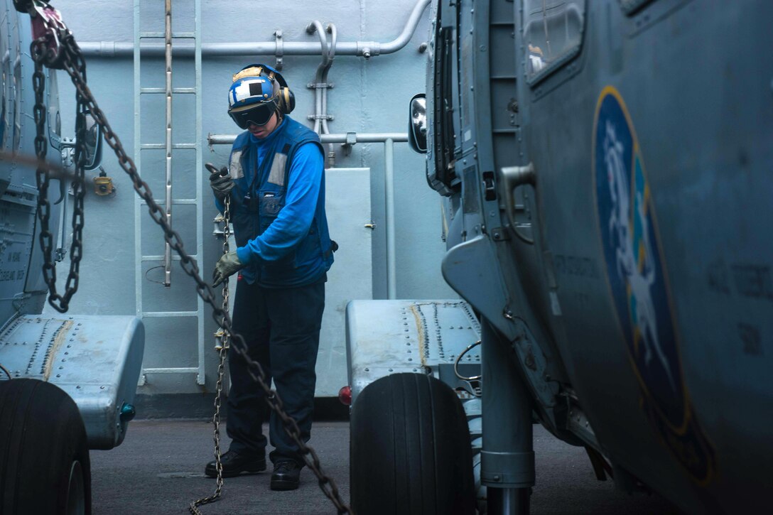 Navy Seaman Elizabeth Nieves prepares to chock and chain a MH-60S Sea Hawk helicopter assigned to the Chargers of Helicopter Sea Combat Squadron 14 on the flight deck of the aircraft carrier USS John C. Stennis in the South China Sea, March 5, 2016. Nieves is an aviation boatswain's mate handling airman. The Stennis is operating as part of the Great Green Fleet on a regularly scheduled 7th Fleet deployment. Navy photo by Petty Officer 3rd Class Kenneth Rodriguez Santiago