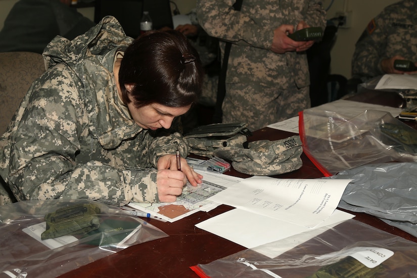 U.S. Army Sgt. Marcy DiOssi of the 102nd Division from  Fort Leonard Wood, Mo. plots a point for an upcoming Land Navigation event during the Best Warrior Competition (BWC) at Camp Bullis, Texas, March 10, 2016. The BWC is an annual competition to identify the strongest and most well-rounded Soldiers through the accomplishment of physical and mental challenges, as well as basic Soldier skills. (U.S. Army photo by Spc. Darnell Torres)