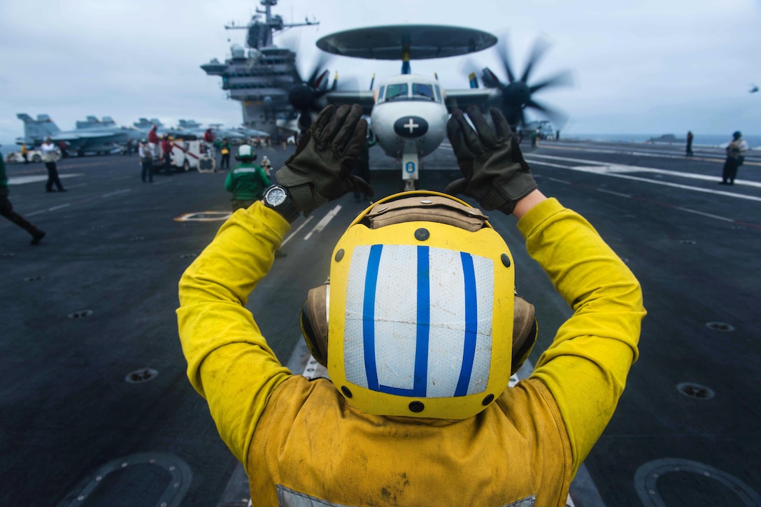 Navy Seaman Leah Wade directs an E-2C Hawkeye aircraft assigned to the Golden Hawks of Airborne Early Warning Squadron 112 on the flight deck of the aircraft carrier USS John C. Stennis in the South China Sea, March 5, 2016. Wade is an aviation boatswain's mate handling airman. Navy photo by Petty Officer 3rd Class Kenneth Rodriguez Santiago