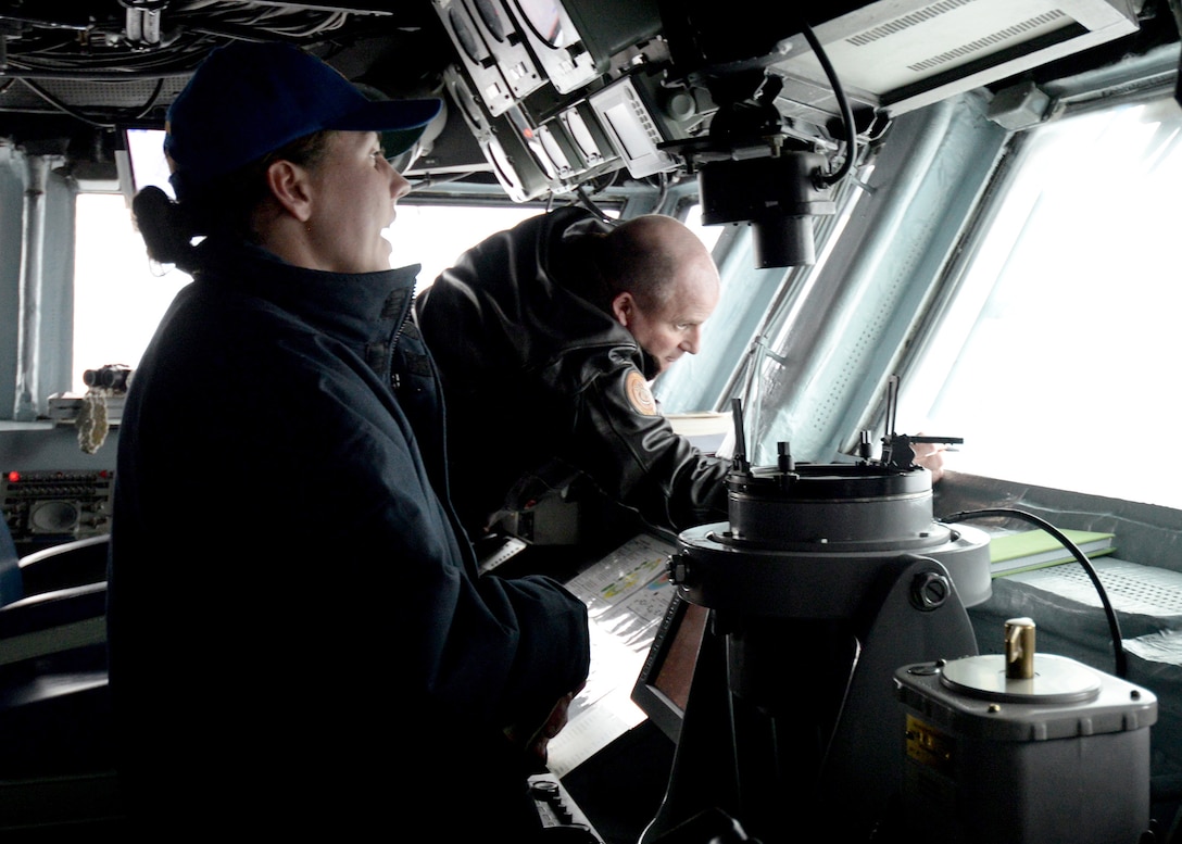 Navy Ensign Jillian Benson, left, relays surface contact bearings to Navy Capt. Mike Ruth, commanding officer of the amphibious assault ship USS Boxer in the pilot house during a photographic exercise with 19 ships from the U.S. and the South Korean navy in the East Sea, March 8, 2016. The Boxer is the flagship of the Boxer Amphibious Ready Group and is participating in exercise Ssang Yong 16.Navy photo by Petty Officer 2nd Class Brian Caracci