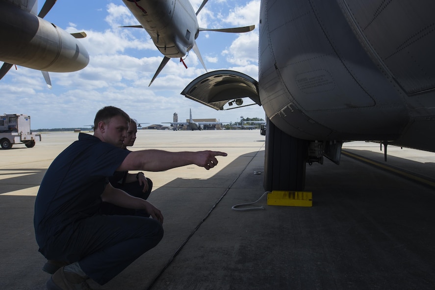 U.S. Air Force Senior Airman Brendan Stienbach, 23d Equipment Maintenance Squadron repair and reclamation journeyman, shows Airman 1st Class Rachel Camp, 23d EMS repair and reclamation apprentice, a drain for an auxiliary fuel tank under a HC-130J Combat King II during an operational checkout, March 9, 2016, at Moody Air Force Base, Ga. Currently, Moody’s HC-130Js do not use auxiliary fuel tanks as a result of newer engines being more fuel efficient. (U.S. Air Force photo by Airman Daniel Snider/Released)
