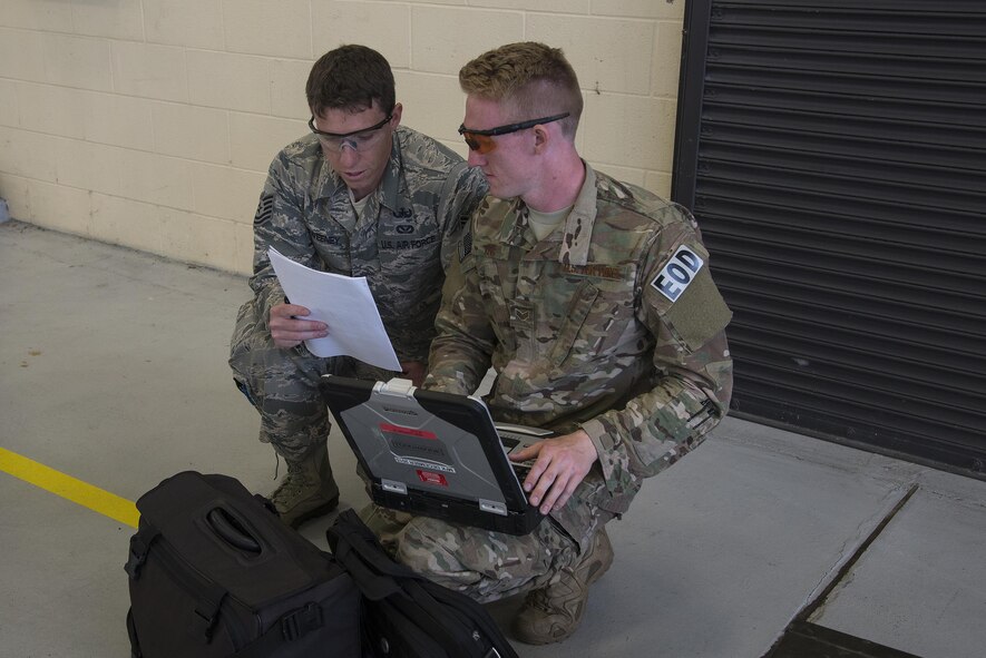 U.S. Air Force Tech. Sgt. Michael Sweeney, 23d Civil Engineer Squadron NCO in charge of equipment (left), and Senior Airman Kaelob King, 23d CES explosive ordinance disposal apprentice, strategize during a team-led qualification training, March 10, 2016, at Moody Air Force Base, Ga. The two-man team worked together to identify and eliminate hazards on an A-10C Thunderbolt II safe. (U.S. Air Force Photo by Airman 1st Class Janiqua P. Robinson/Released)