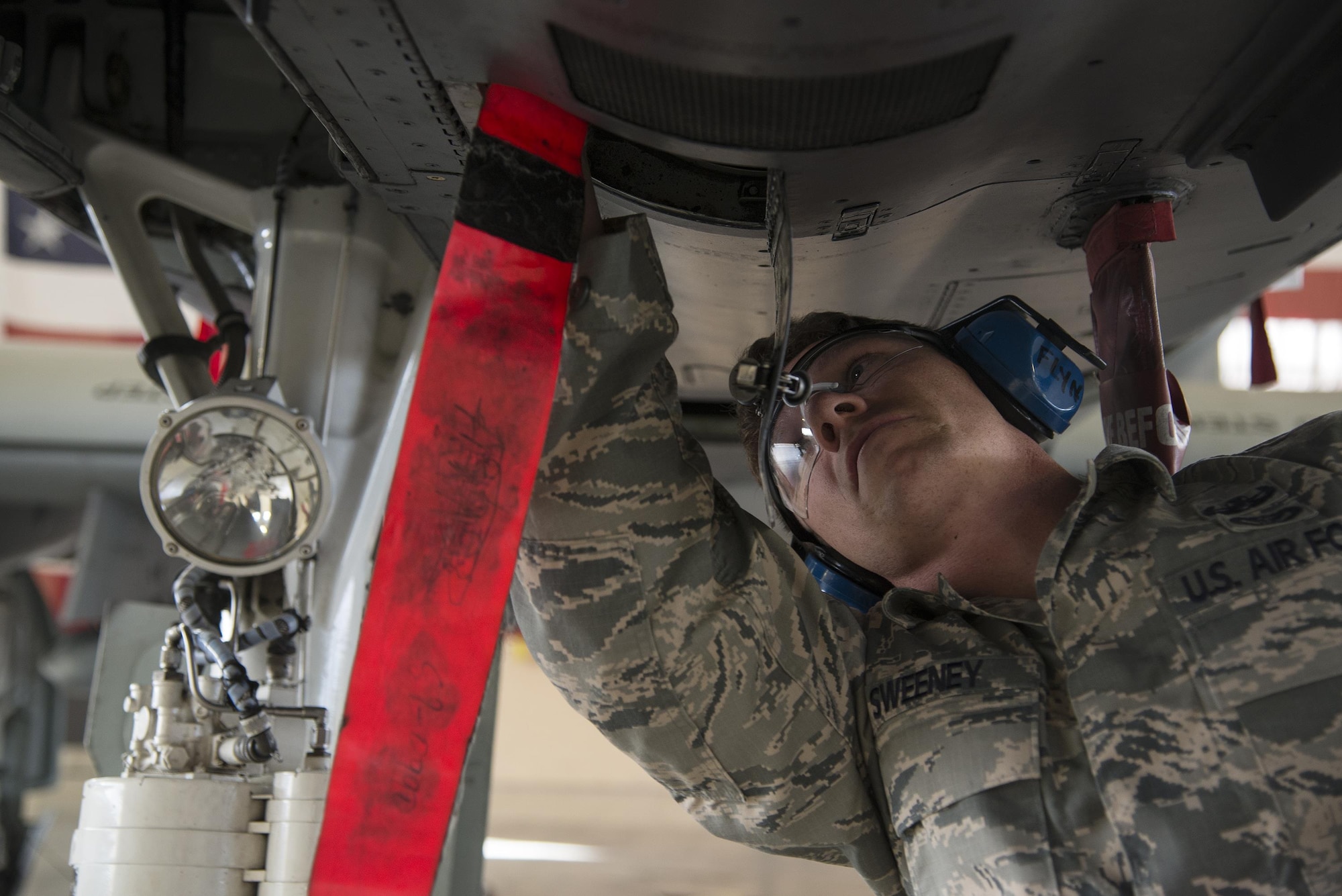 U.S. Air Force Tech. Sgt. Michael Sweeney, 23d Civil Engineer Squadron NCO in charge of equipment, inserts a pin into an A-10C Thunderbolt II during a team-led qualification training, March 10, 2016 at Moody Air Force Base, Ga. An explosive ordinance disposal team is notified  and must disarm any explosive hazard on an Aircraft. (U.S. Air Force photo by Airman 1st Class Janiqua P. Robinson/Released)
