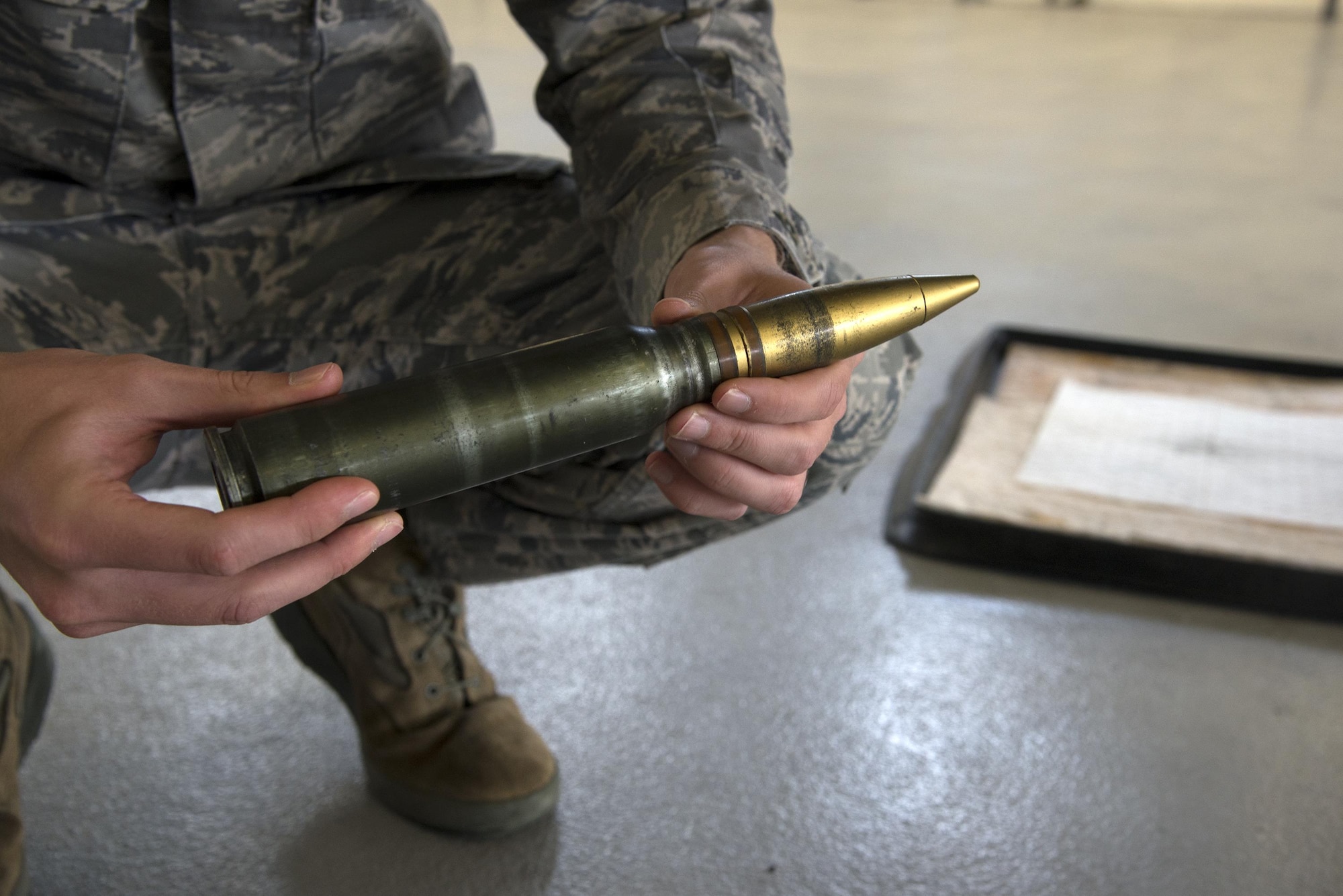 U.S. Air Force Staff Sgt. Cody Miller, 23d Civil Engineer Squadron explosive ordinance disposal journeyman, examines a simulated hazard during a team-led qualification training, March 10, 2016, at Moody Air Force Base, Ga. The simulated hazard was a punctured projectile covered with fuel that fell out of an A-10C Thunderbolt II after flight. (U.S. Air Force Photo by Airman 1st Class Janiqua P. Robinson/Released)