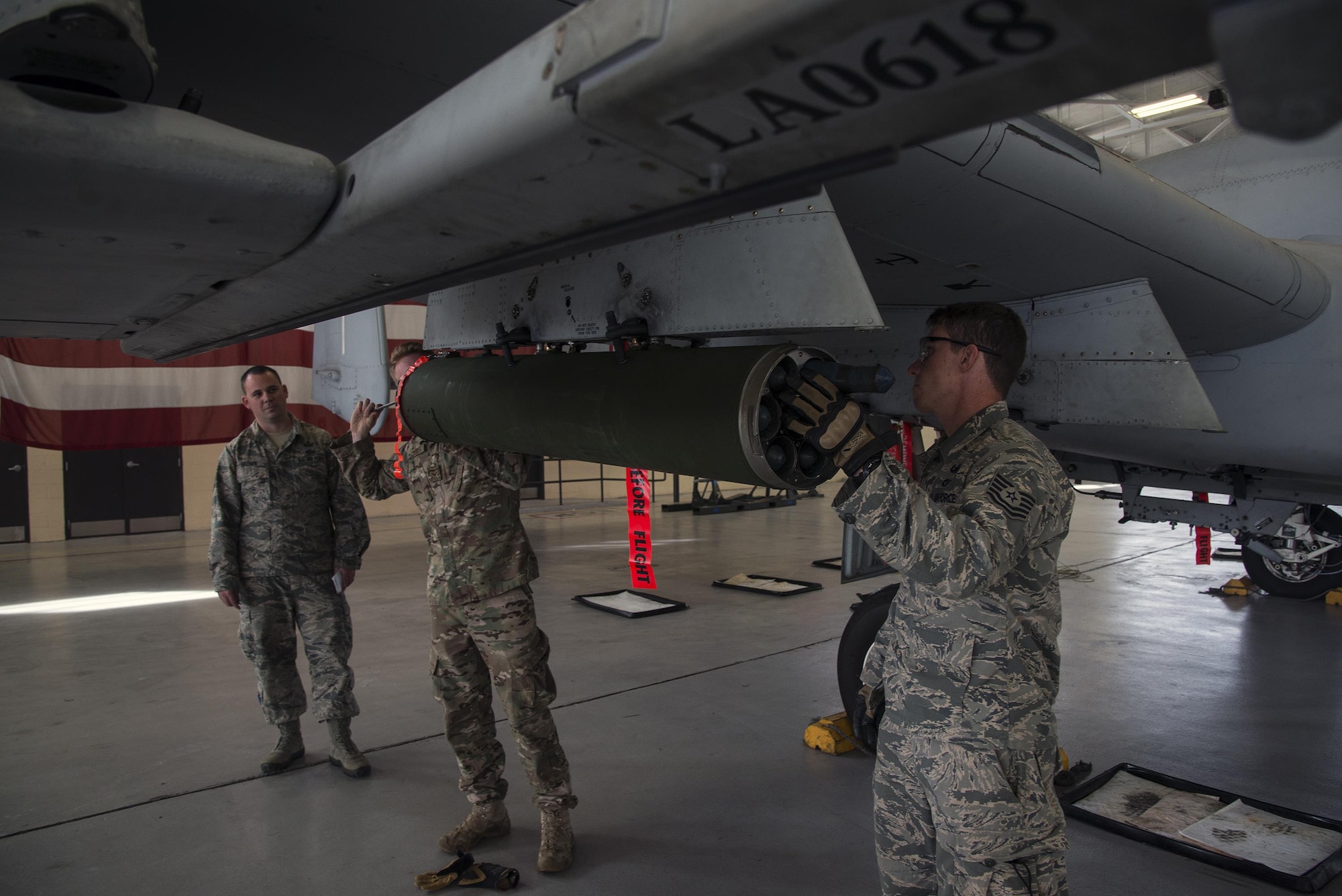U.S. Air Force Staff Sgt. Kyle Brown, 23d Civil Engineer Squadron NCO in charge of supply (left), evaluates Tech. Sgt. Michael Sweeney, 23d CES NCOIC of equipment (right), while Senior Airman Kaelob King, 23d CES explosive ordinance disposal apprentice (center), assists during a team-led qualification training, March 10, 2016, at Moody Air Force Base, Ga. Leadership from the 23d CES EOD unit simulated and graded two scenarios in which a two-man team would be called to respond and make an A-10C Thunderbolt II safe. (U.S. Air Force Photo by Airman 1st Class Janiqua P. Robinson/Released)