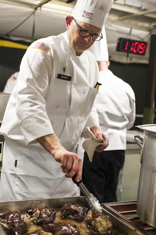 U.S. Army Reserve Culinary Arts Team manager, Chief Warrant Officer 2 Colby Beard, with the 11th Theater Aviation Command, cooks chicken during the Military Hot Food Kitchen category at the 41st Annual Military Culinary Arts Competitive Training Event, March 10, 2016, at Fort Lee, Va. The team prepared Roasted Golden and Burgundy Beet Salad, Coq au Vin Nuevo (Chicken braised in red wine), and Molten Lava Cake working on a Mobile Kitchen Trailer for 45 dining guests. (U.S. Army photo by Timothy L. Hale/Released)