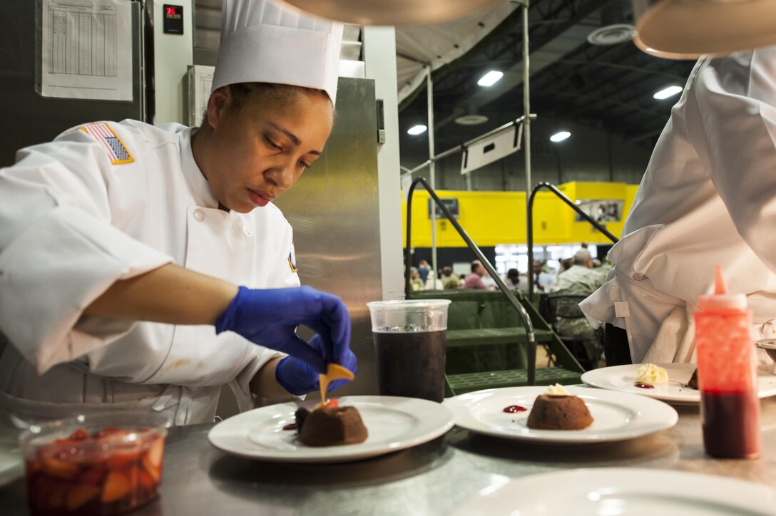 U.S. Army Reserve Culinary Arts Team member Staff Aqueelah James, plates her dessert during the Military Hot Food Kitchen category at the 41st Annual Military Culinary Arts Competitive Training Event, March 10, 2016, at Fort Lee, Va.. The team prepared Roasted Golden and Burgundy Beet Salad, Coq au Vin Nuevo (Chicken braised in red wine), and Molten Lava Cake working on a Mobile Kitchen Trailer for 45 dining guests. (U.S. Army photo by Timothy L. Hale) (Released)