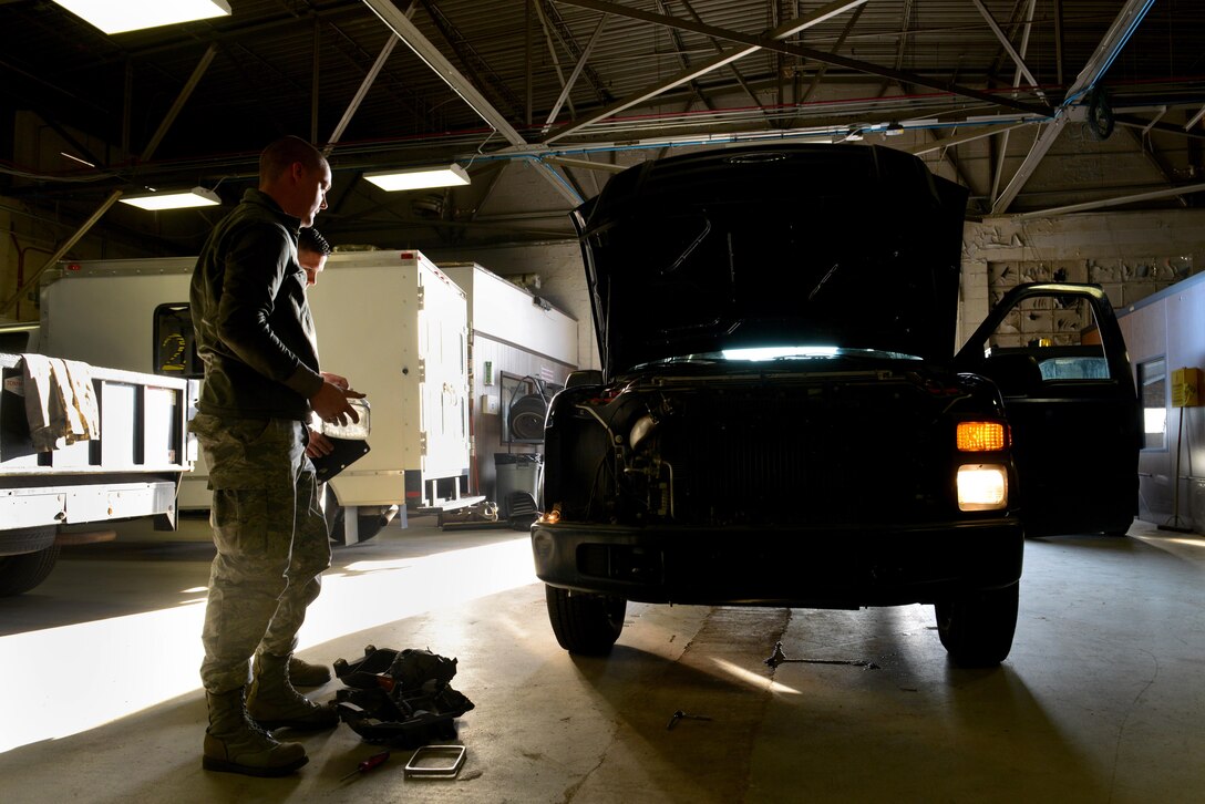 U.S. Airmen assigned to the 20th Logistics Readiness Squadron vehicle maintenance flight inspect a government-owned vehicle at Shaw Air Force Base, S.C., March 8, 2016. The vehicle had a broken headlight and required maintenance. (U.S. Air Force photo by Airman 1st Class Destinee Dougherty)