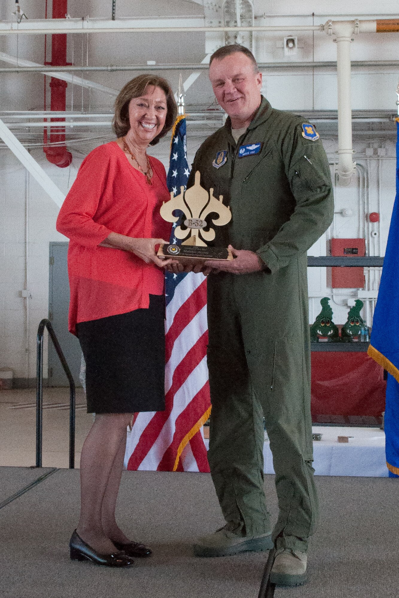 The Commander of the 307th Bomb Wing, U.S. Air Force Col. Bruce Cox, presents Ms. Melanie Acosta with a trophy during a Commander’s Call on March 6, 2015 on Barksdale Air Force Base, La. Ms. Acosta was awarded the 307th Bomb Wing’s 2016 Civilian of the Year for her outstanding work in the 307th Operations Support Squadron.(U.S. Air Force photo by Master Sgt. Dachelle Melville/Released)