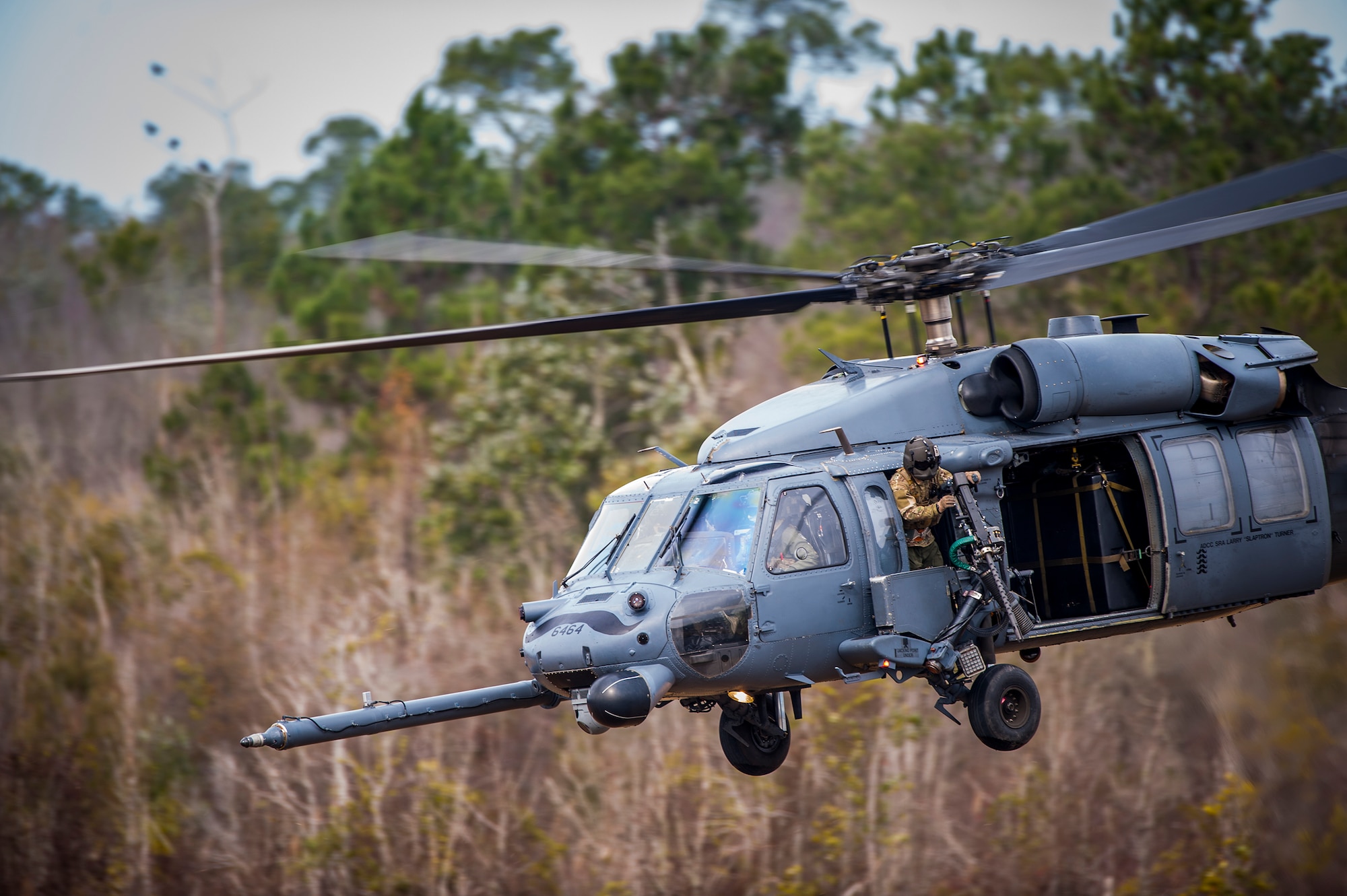 Airmen from the 41st Rescue Squadron take off in an HH-60G Pave Hawk helicopter during a training exercise, Jan. 26, 2016, at Moody Air Force Base, Ga. The HH-60G is armed with two individually-manned .50-caliber machine guns that Airmen fired at ground targets during the training. (U.S. Air Force photo by Airman 1st Class Lauren M. Johnson/Released)