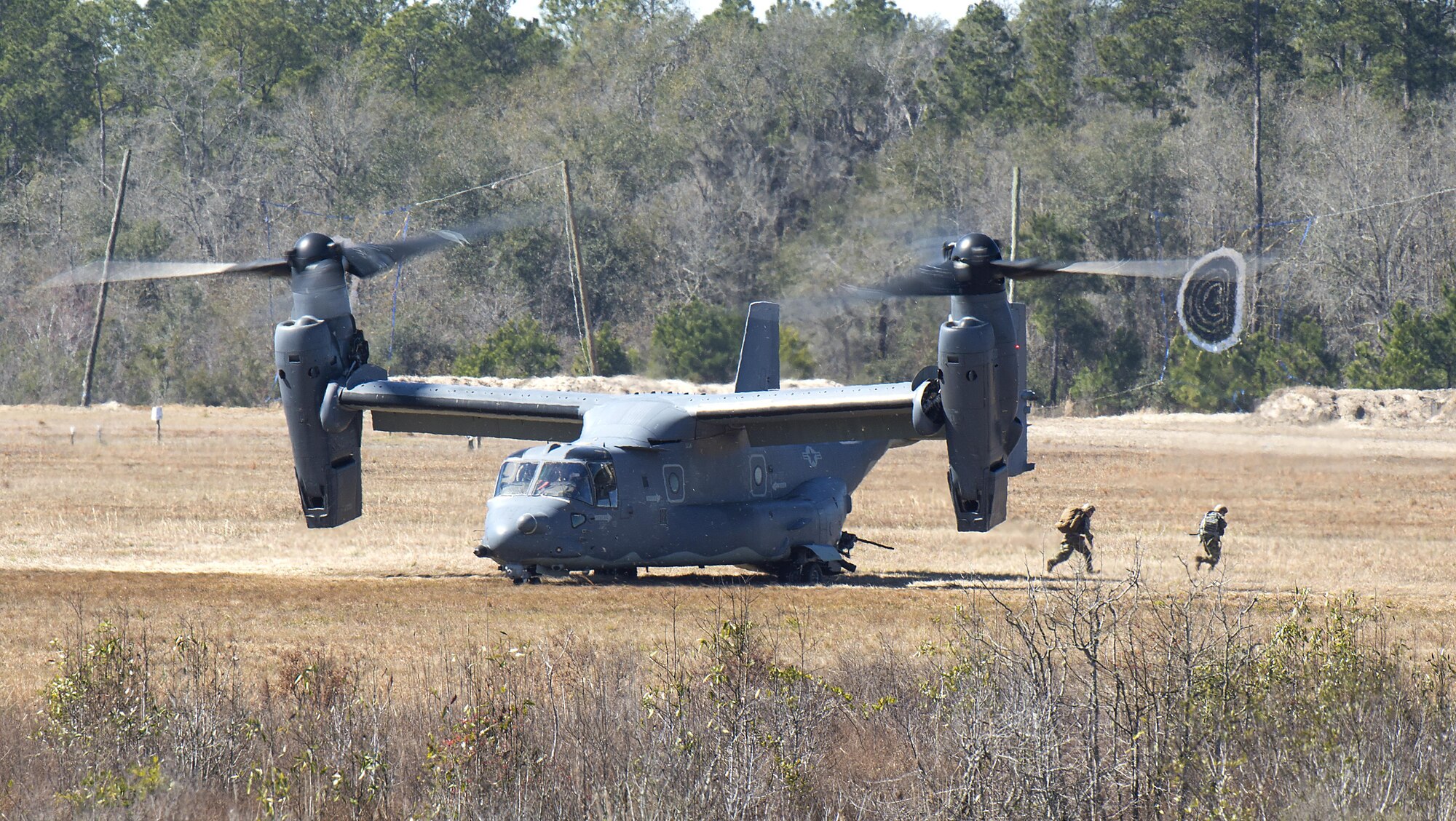 A CV-22 Osprey deploys a tactical air control party onto the ground of Grand Bay Bombing and Gunnery Range at Moody Air Force Base, Ga., Feb. 18, 2016. Multiple U.S. Air Force aircraft within Air Combat Command conducted joint combat rescue and aerial training that showcased the aircrafts tactical air and ground maneuvers, as well as its weapons capabilities. (U.S. Air Force photo by Staff Sgt. Brian J. Valencia/Released)