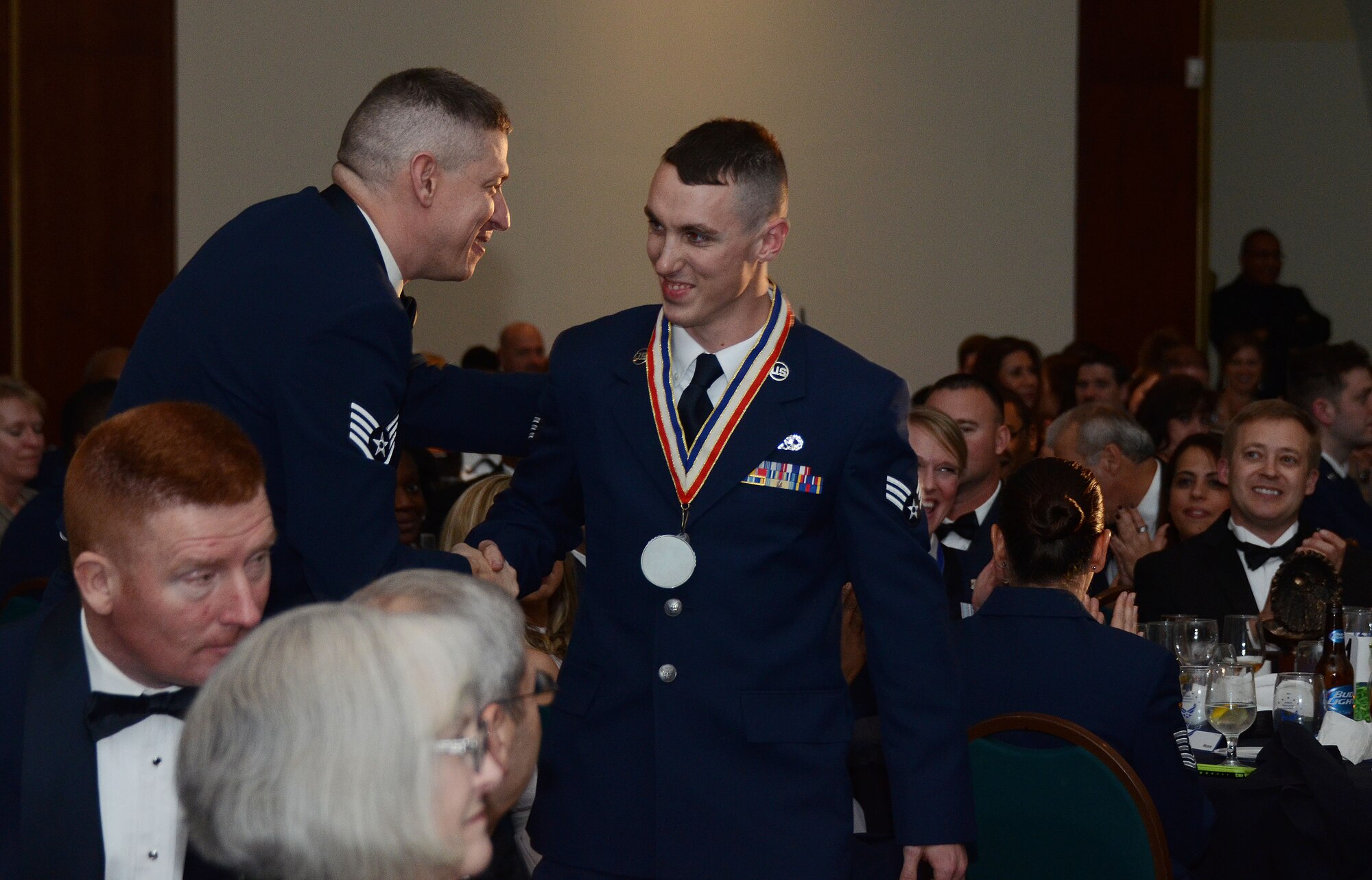 Airman of the Year, SrA David Yancey, 94th Aircraft Maintenance Squadron, receives a congratulatory handshake before walking up to receive his award. (Photo by U.S. Air Force/ Don Peek)