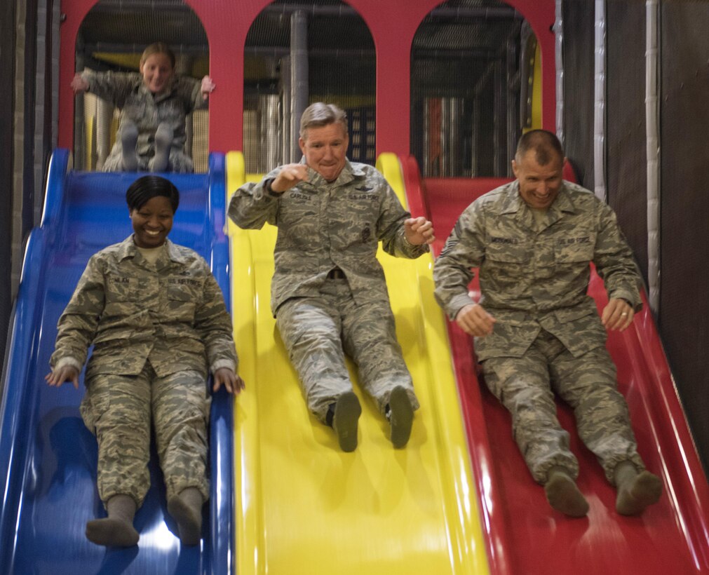 U.S. Air Force Gen. Hawk Carlisle, commander of Air Combat Command, enjoys a trip down a slide at the Gunfighter Kids' Gym with Command Chief Master Sgt. Steve McDonald, ACC command chief, and Senior Master Sgt. Anedra Conlan, 366th Force Support Squadron sustainment flight superintendent, at Mountain Home Air Force Base, Idaho, March 7, 2016. Carlisle spent two days at the base meeting with airman and their units, discussing ongoing Air Force issues. (U.S. Air Force photo by Senior Airman Jeremy L. Mosier/Released)