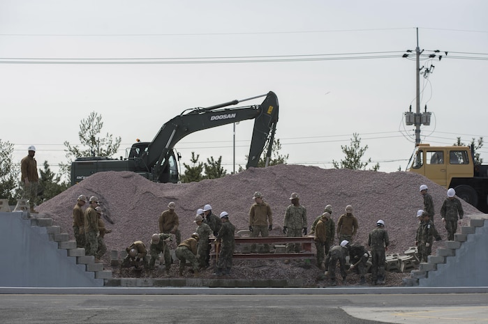 160310-N-HA376-210 JINHAE, Republic of Korea (March 9, 2016) - U.S. Navy and Republic of
Korea (ROK) Seabees place concrete block and move aggregate during exercise Foal Eagle
2016. The Seabees, assigned to Naval Mobile Construction Battalion (NMCB) 4, and ROK
Seabees are training together at the ROK Engineering School during the exercise. Foal Eagle is an annual, bilateral training exercise designed to enhance the readiness of U.S. and ROK forces, and their ability to work together during a crisis. (U.S. Navy photo by Chief Mass Communication Specialist Lowell Whitman/Released)