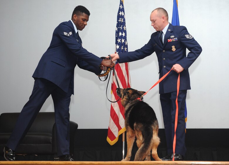 Staff Sgt. Dustin Combs, 22nd Security Forces Squadron military working dog, hands over Bengus’ MWD collar after replacing it with a ‘civilian’ dog collar and leash, March 11, 2016, at McConnell Air Force Base, Kan. The changing of collars represented Bengus’ transition from a MWD to household pet. (U.S. Air Force photo/Senior Airman Tara Fadenrecht)