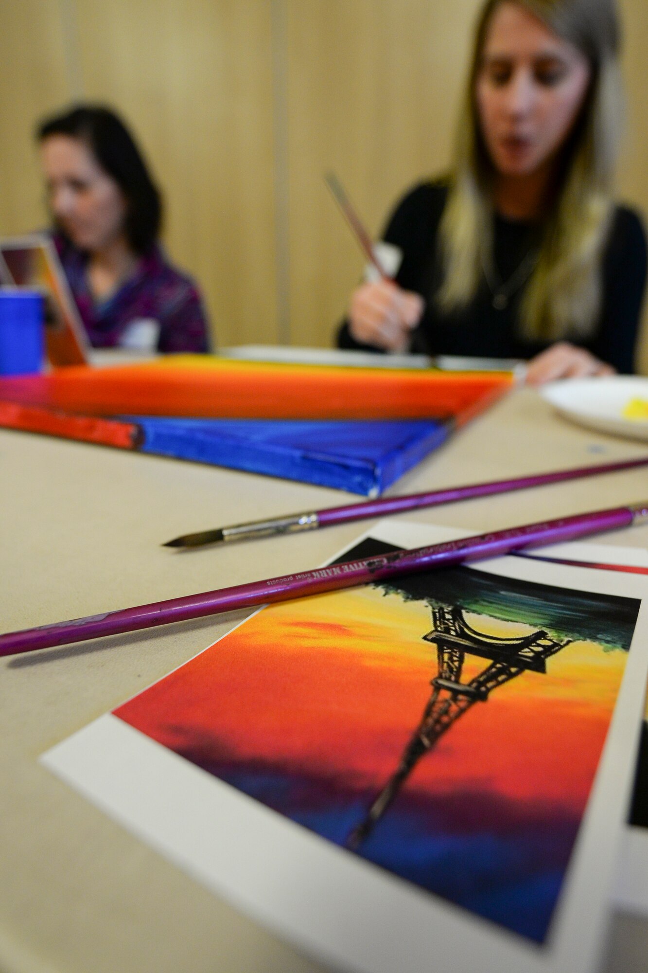 Team Mildenhall spouses paint canvases during a Hearts Apart event for families of deployed Airmen March 10, 2016, at the Bob Hope Community Center on RAF Mildenhall, England. Volunteers from the RAF Mildenhall Top Three Fellowship provided childcare to allow spouses with children the opportunity to relax and unwind. (U.S. Air Force photo by Staff Sgt. Micaiah Anthony/Released)