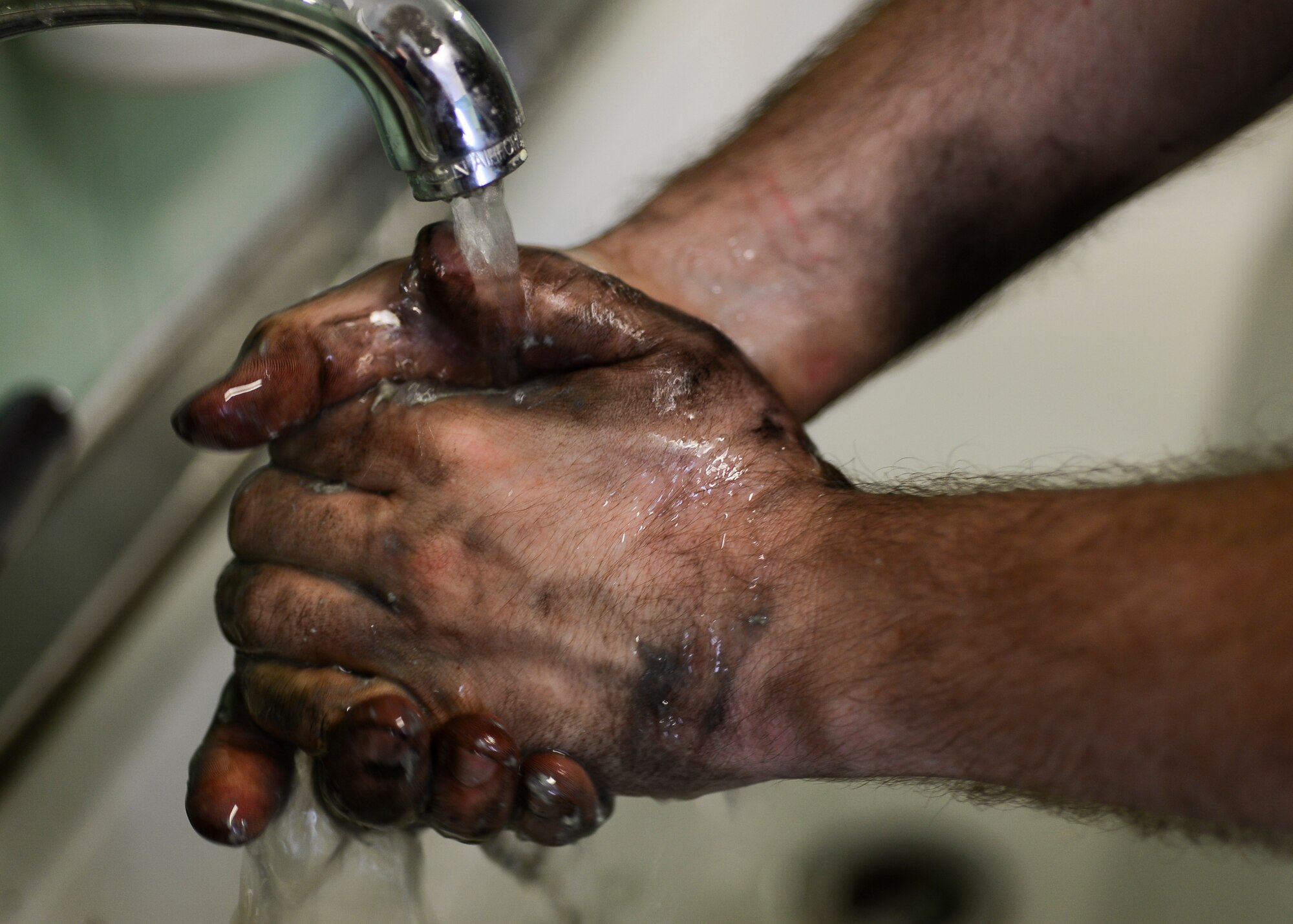 Senior Airman David Ramsey, 31st Logistics Readiness Squadron vehicle maintenance journeyman, washes his hands March 2, 2015, at Aviano Air Base, Italy. The vehicle maintenance flight takes care of scheduled, minor, equipment, fire truck and material handling vehicle maintenance. (U.S. Air Force photo by Airman 1st Class Cory W. Bush/Released)