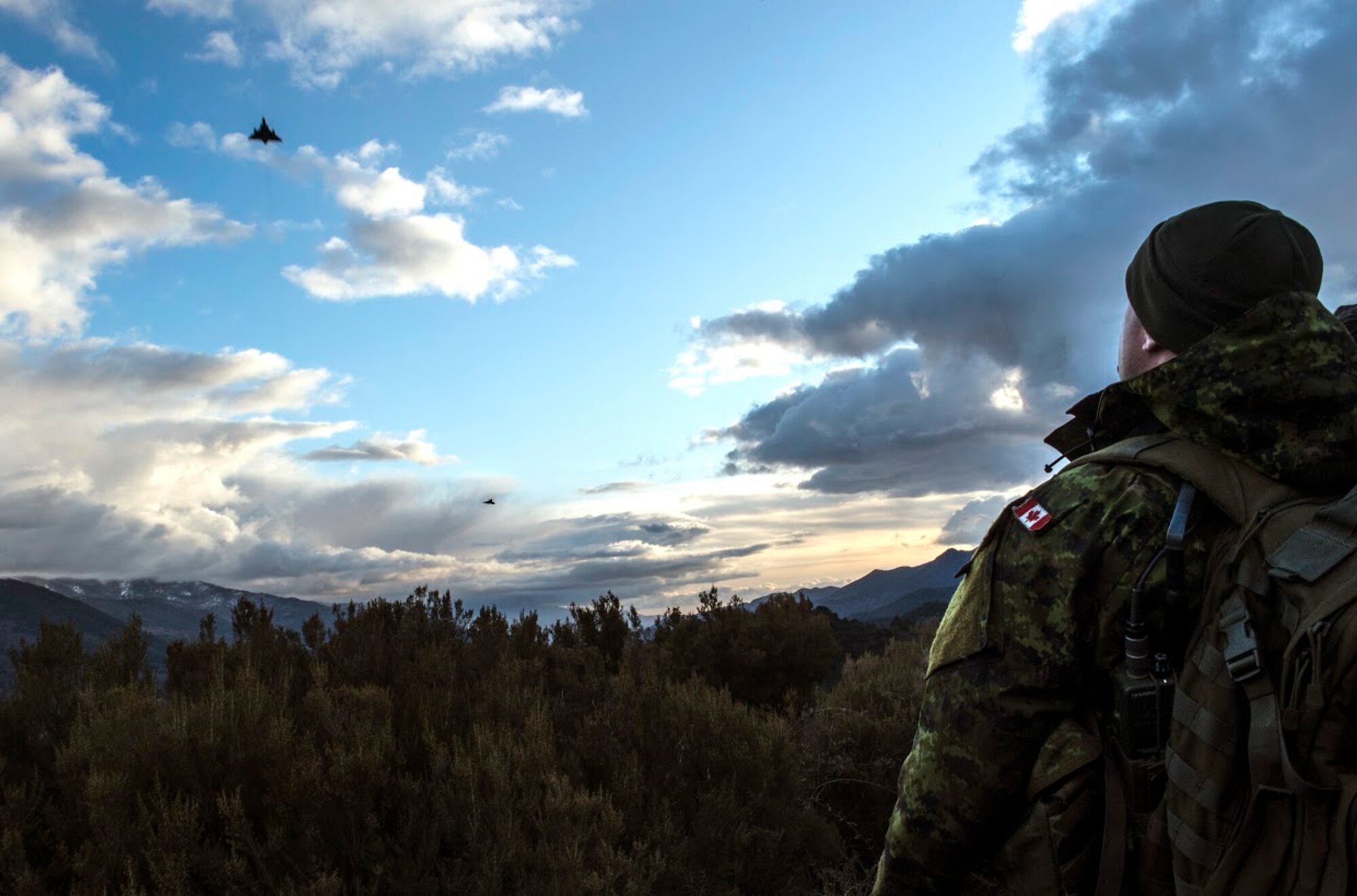 Master Bombardier Mathiew Marcoux-Desrochers, a joint terminal attack controller from the Yankee Battery of the 2nd Regiment, Royal Canadian Horse Artillery, watches as French air force fighter jets fly over head during exercise Serpentex 16, March 9, 2016. The RCHA worked side-by-side U.S. and French JTACs for several days as part of theater security cooperation engagements. The NATO exercise demonstrated a shared commitment to promoting security and stability between 12 countries. (U.S. Air Force/Staff Sgt. Sara Keller)