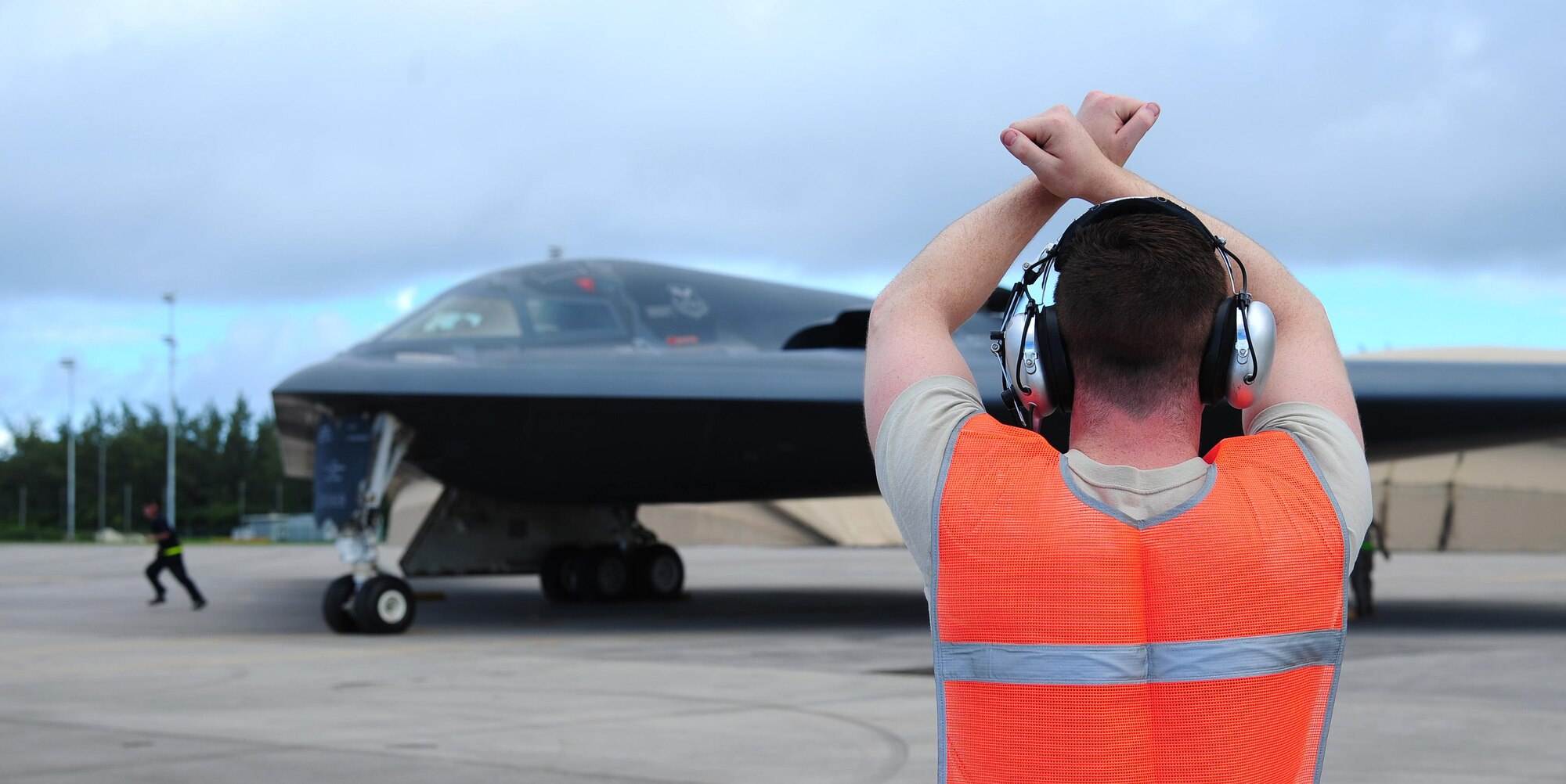 U.S. Air Force Senior Airman Adam Sweet, a crew chief from the 393rd Aircraft Maintenance Unit, prepares to marshal a B-2 Spirit while deployed at an undisclosed location in the U.S. Pacific Command area of operations March 10, 2016. Bomber crews routinely deploy to maintain a high state of readiness and crew proficiency while integrating capabilities with key regional partners. (U.S. Air Force photo by Senior Airman Joel Pfiester/Released)