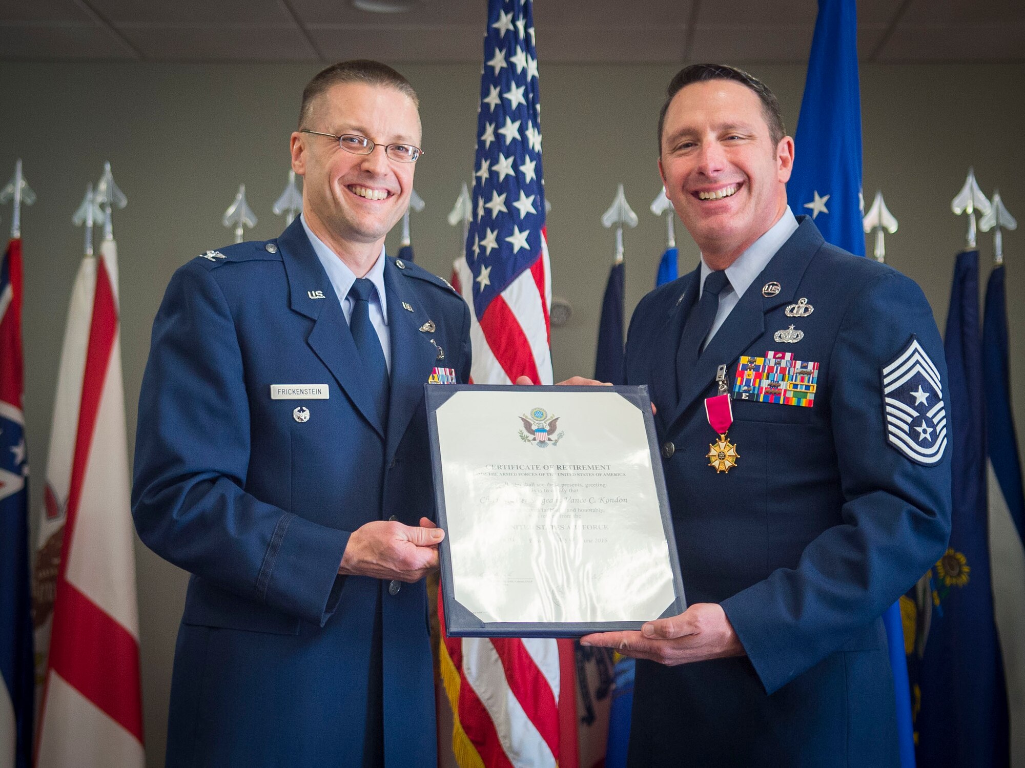 Col. Scott Frickenstein, presiding officer, presents Chief Master Sgt. Vance Kondon with his Certificate of Retirement during his retirement ceremony at the Community Commons on Joint Base Andrews, Md.,  March 11, 2016.  The Chief retired after 30 years of service, spending two years as command chief at JBA. (U.S. Air Force photo by Senior Airman Mariah Haddenham / Released)