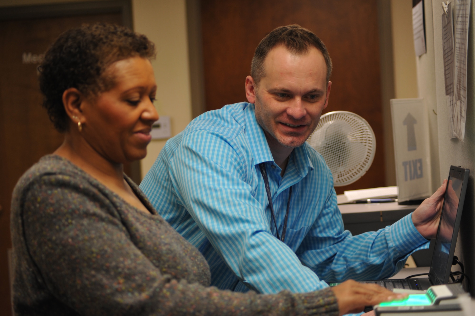 Mike Hosmon (left), personnel security, administers a fingerprint test to Iris Grier. (U.S. Air Force photo/Sandy Simison)